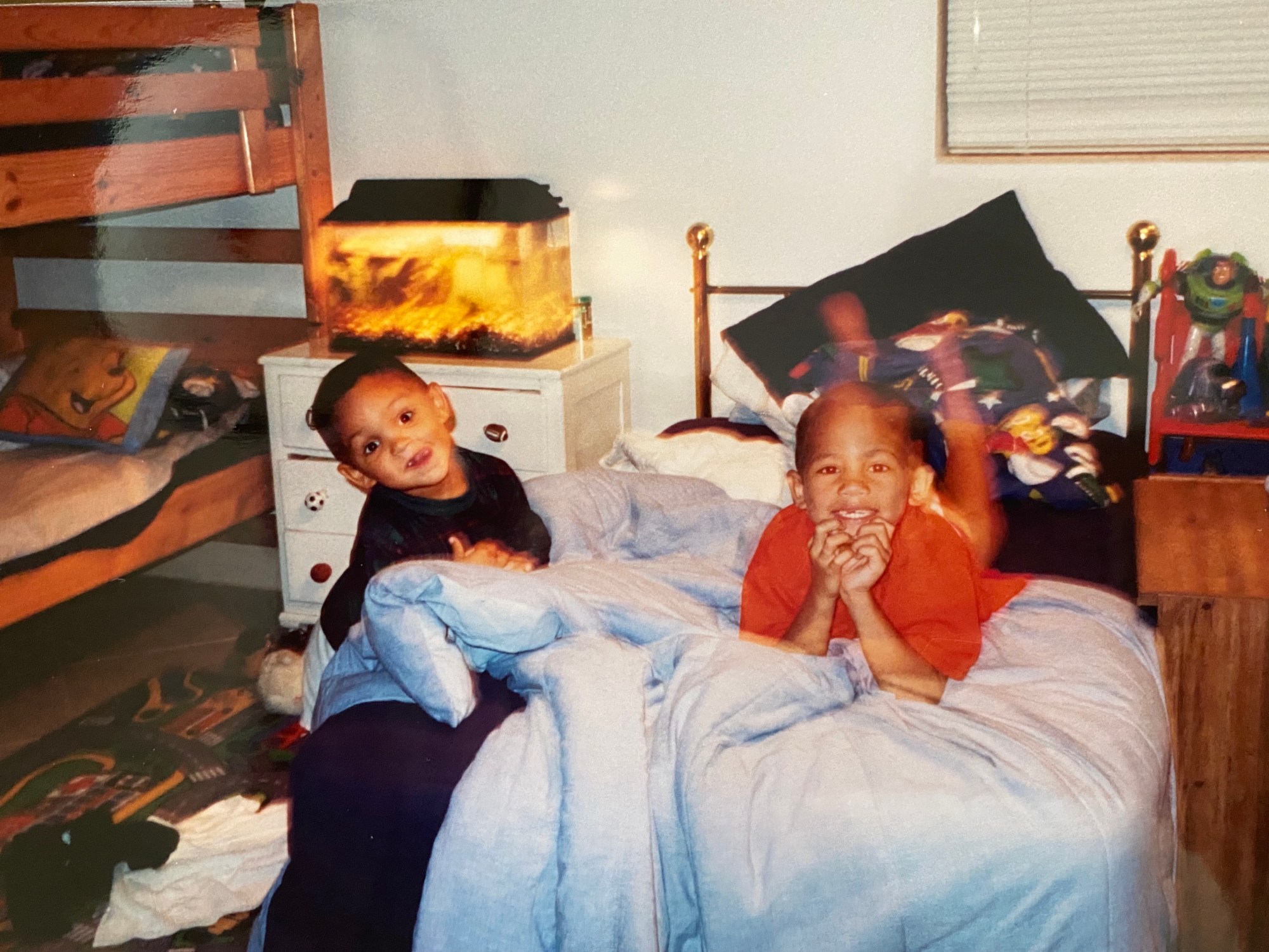 a photo of alex and dominic fike laying on their bed as kids