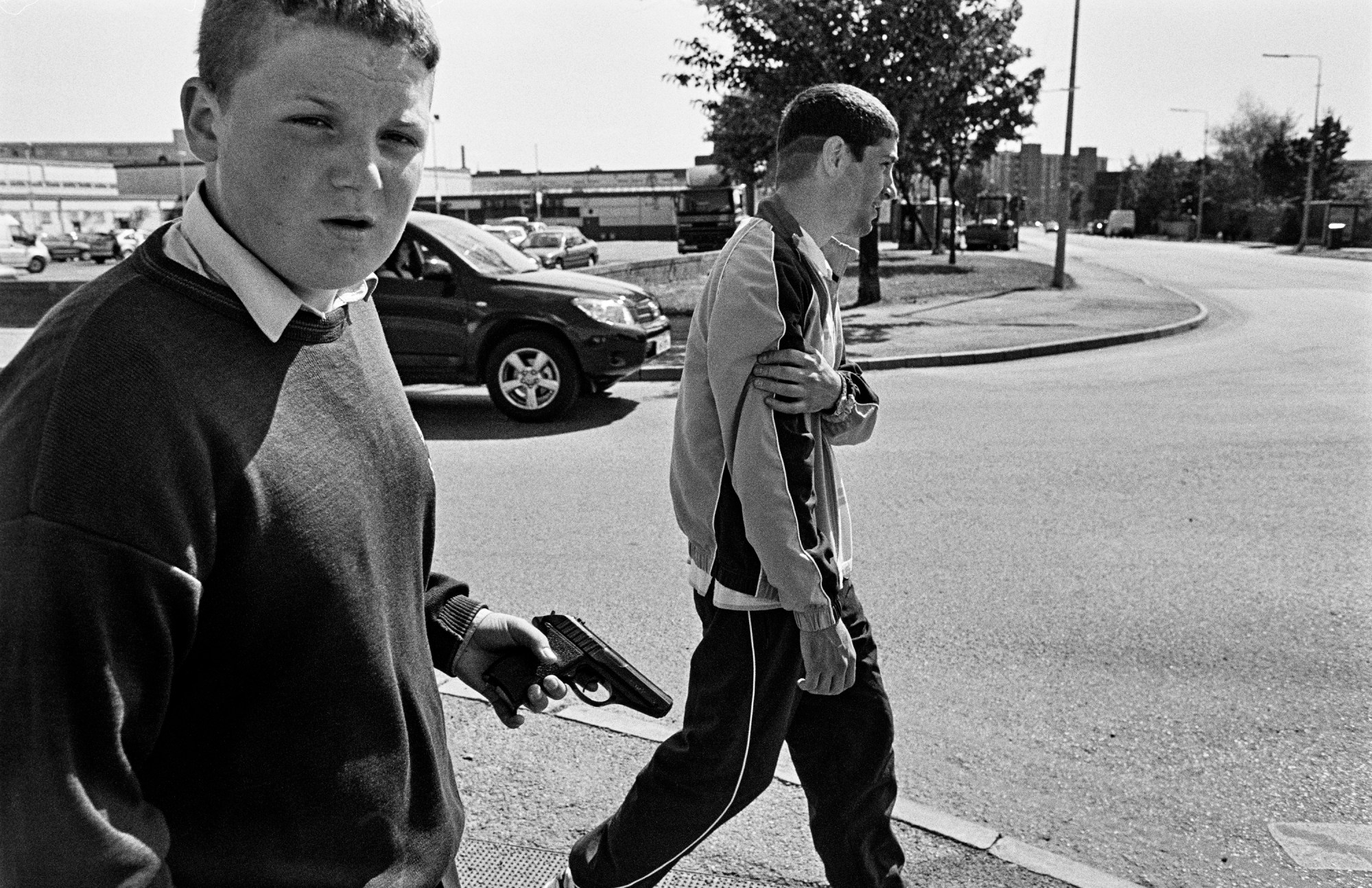 two young men, one holding a gun