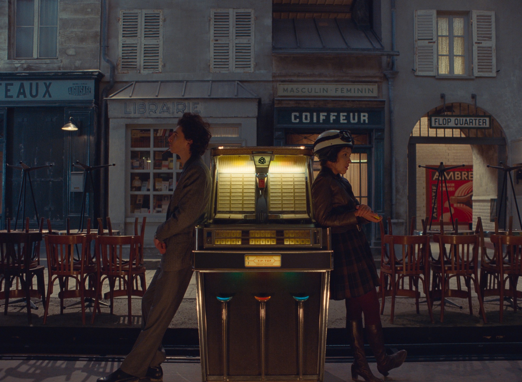 timothee chalamet and lyna khoudri lean against a jukebox in wes anderson's the french dispatch