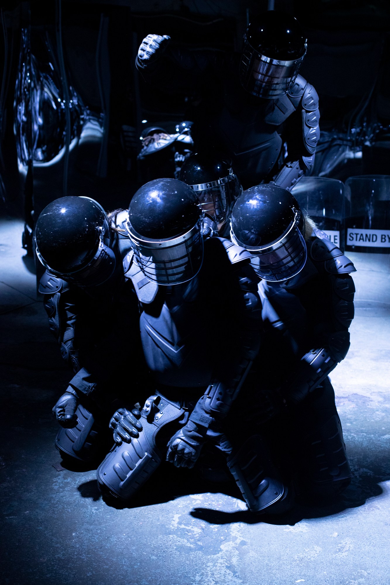 people in riot gear simulate fighting