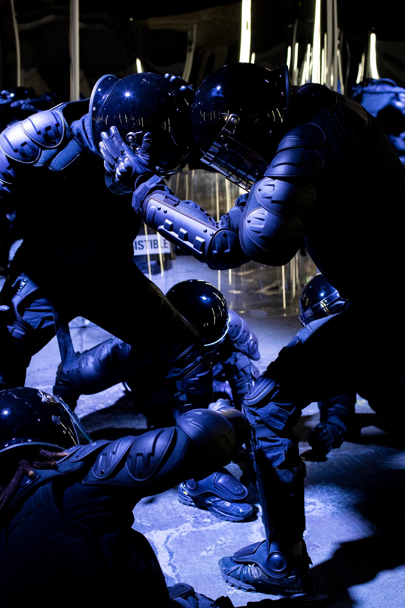 people in riot gear simulate fighting