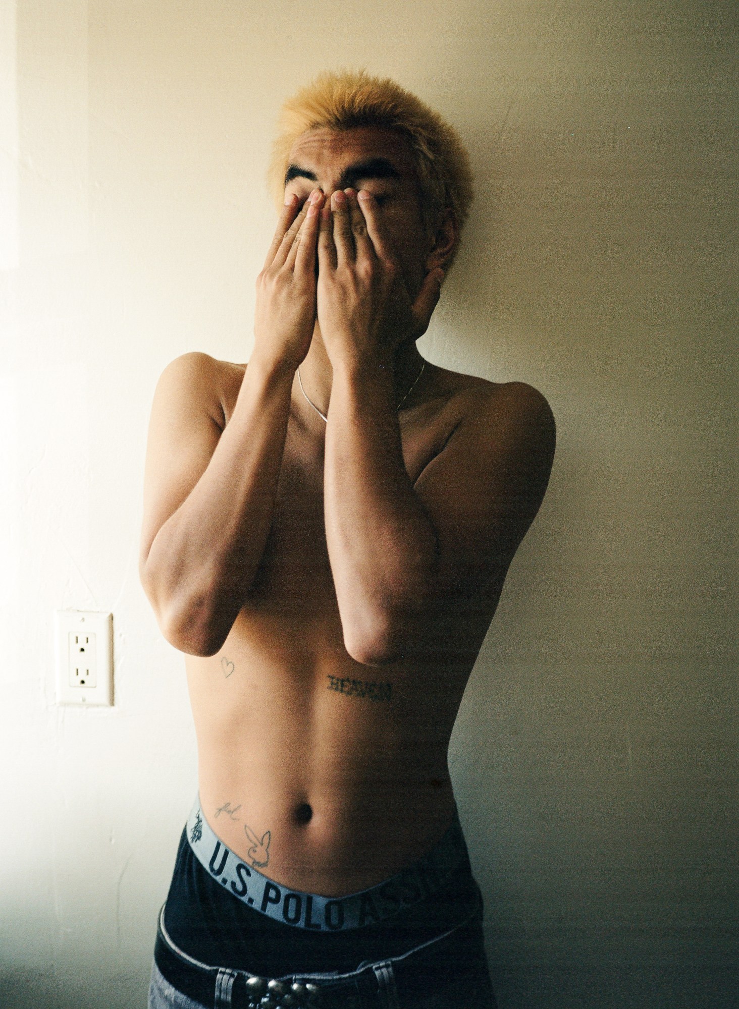 shirtless blonde boy rubs his eyes