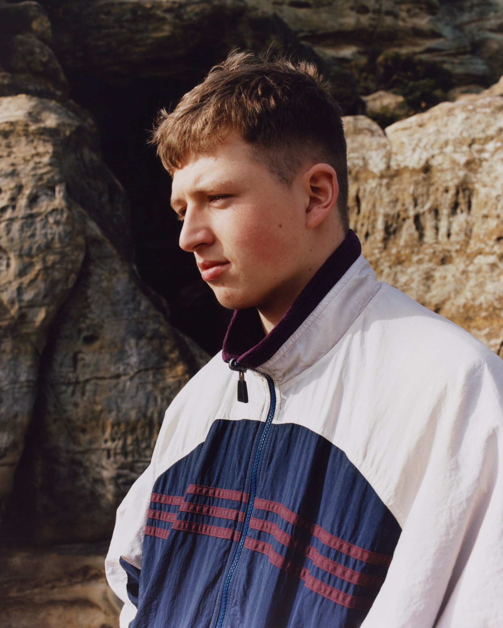 boy in windbreaker looks off camera