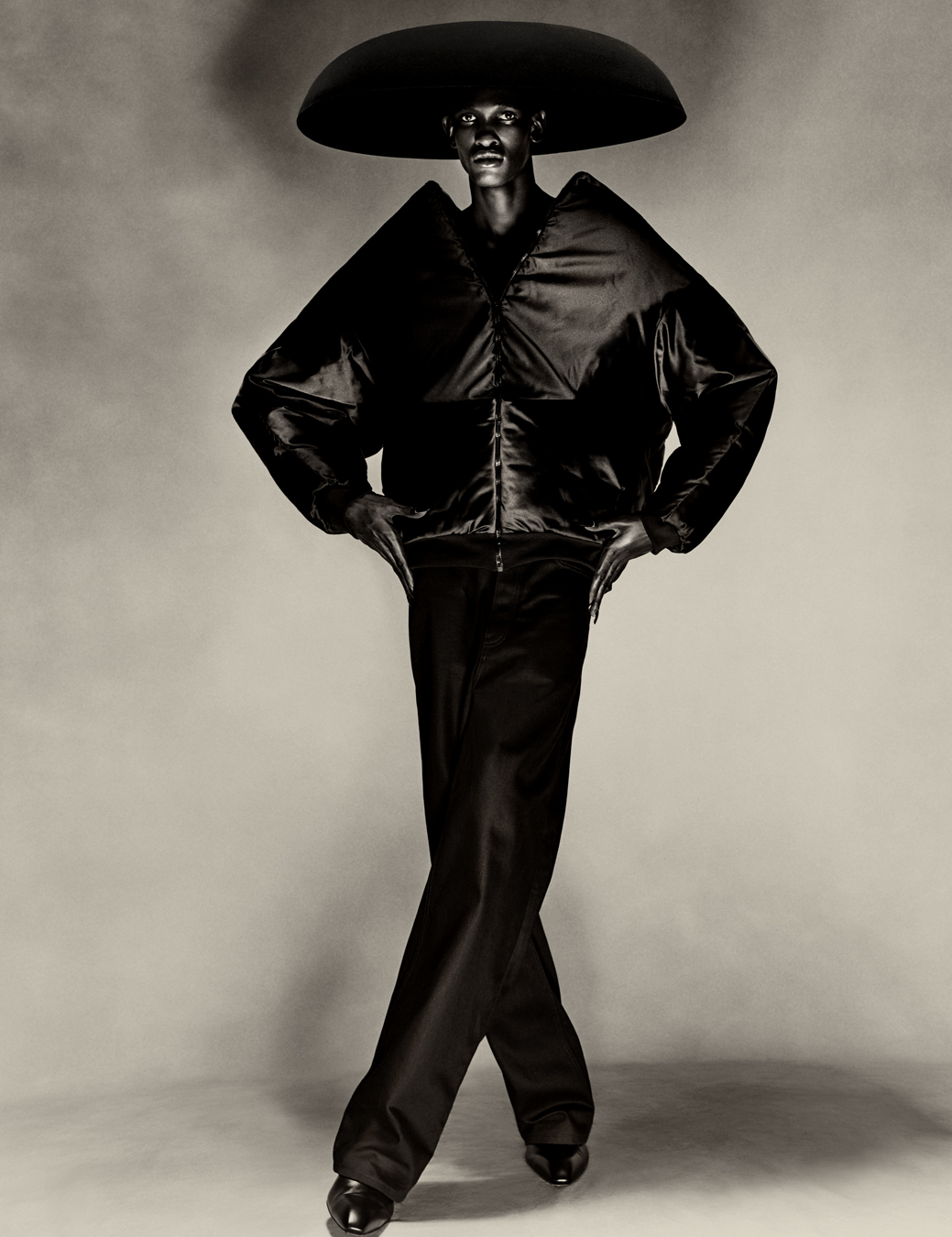 model wears trousers, puffer jacket and umbrella hat all Balenciaga