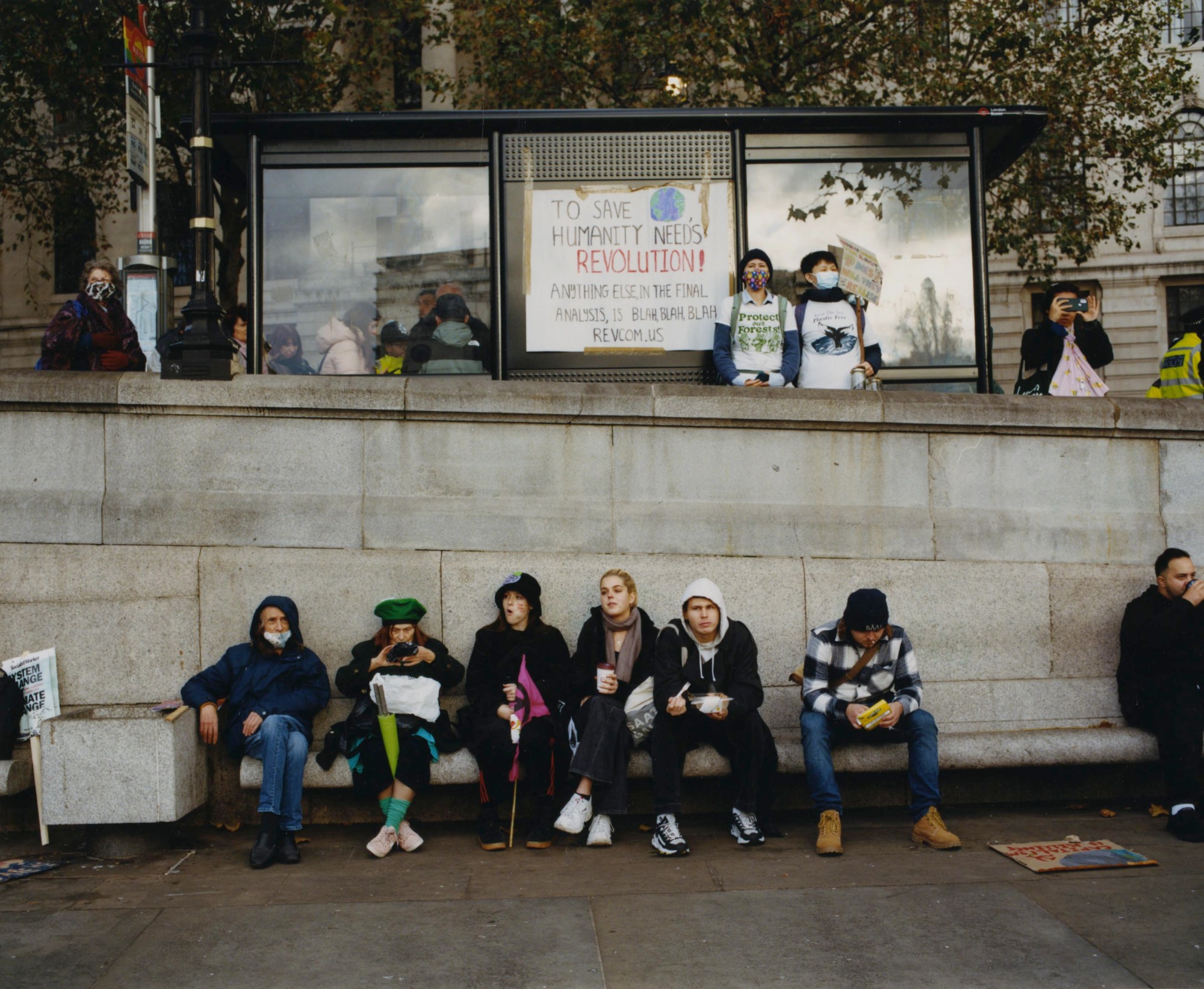 a group of protestors sitting on a bench by heather glazzard