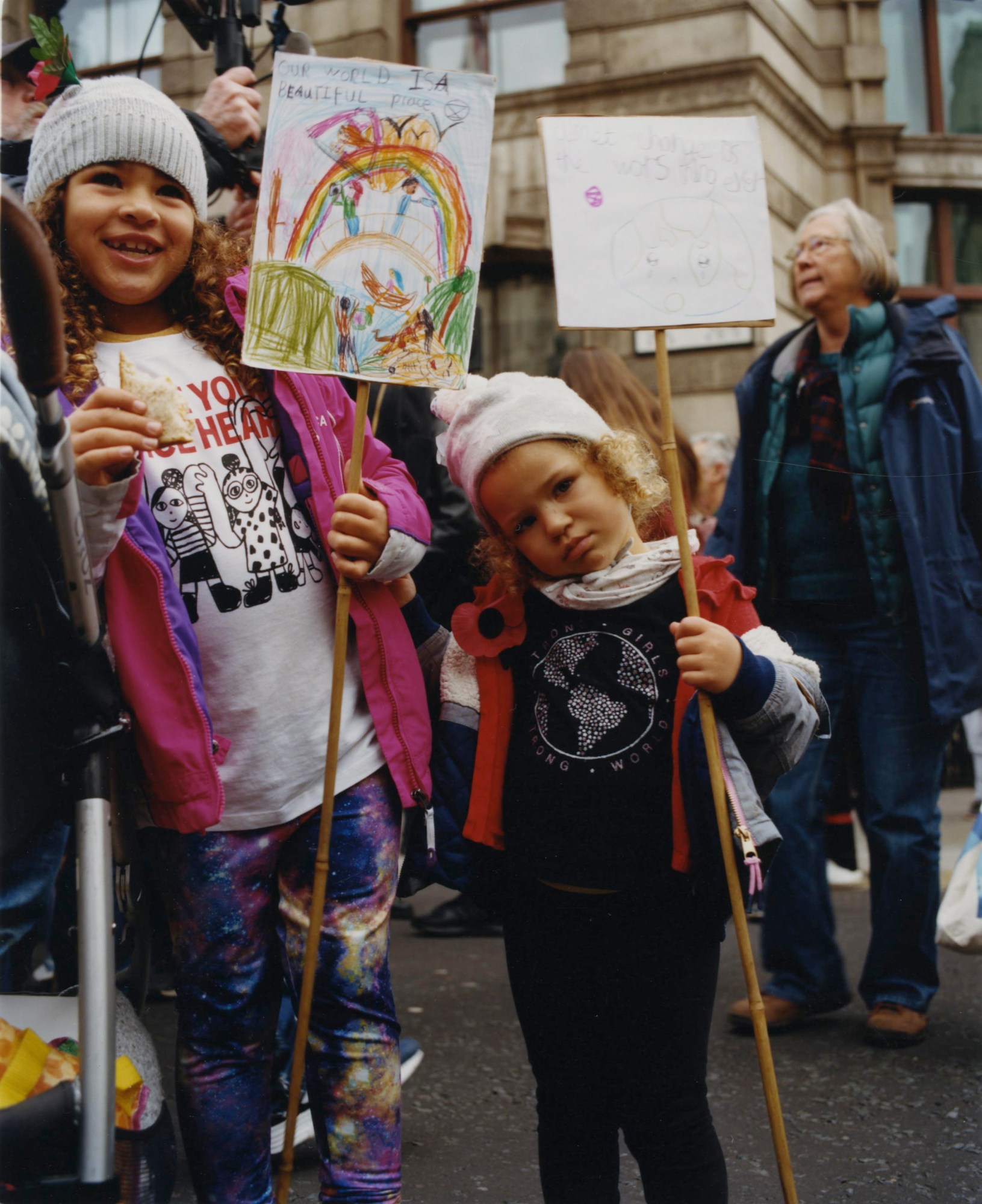 two young girls holding handrawn signs at a climate protest by heather glazzard