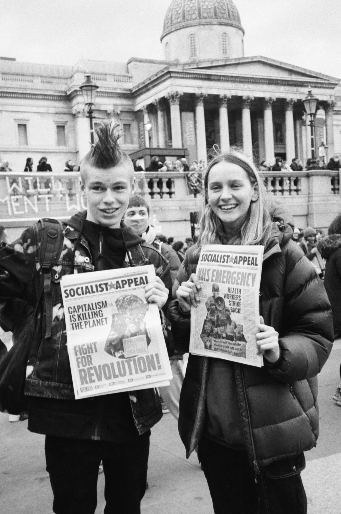 two young protestors holding socialist appeal papers by heather glazzard