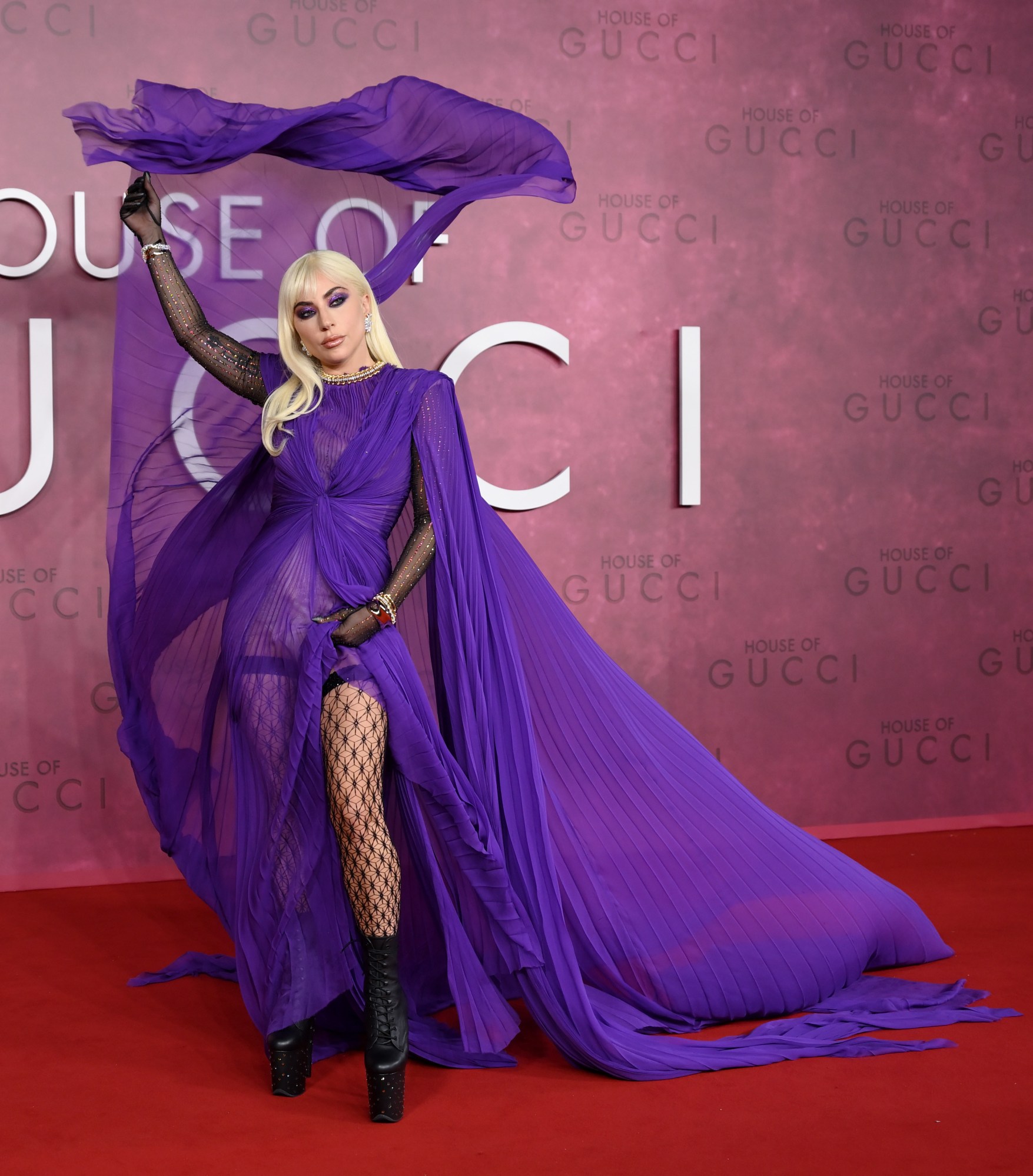 lady gaga posing on the red carpet at the house of gucci premiere 2021