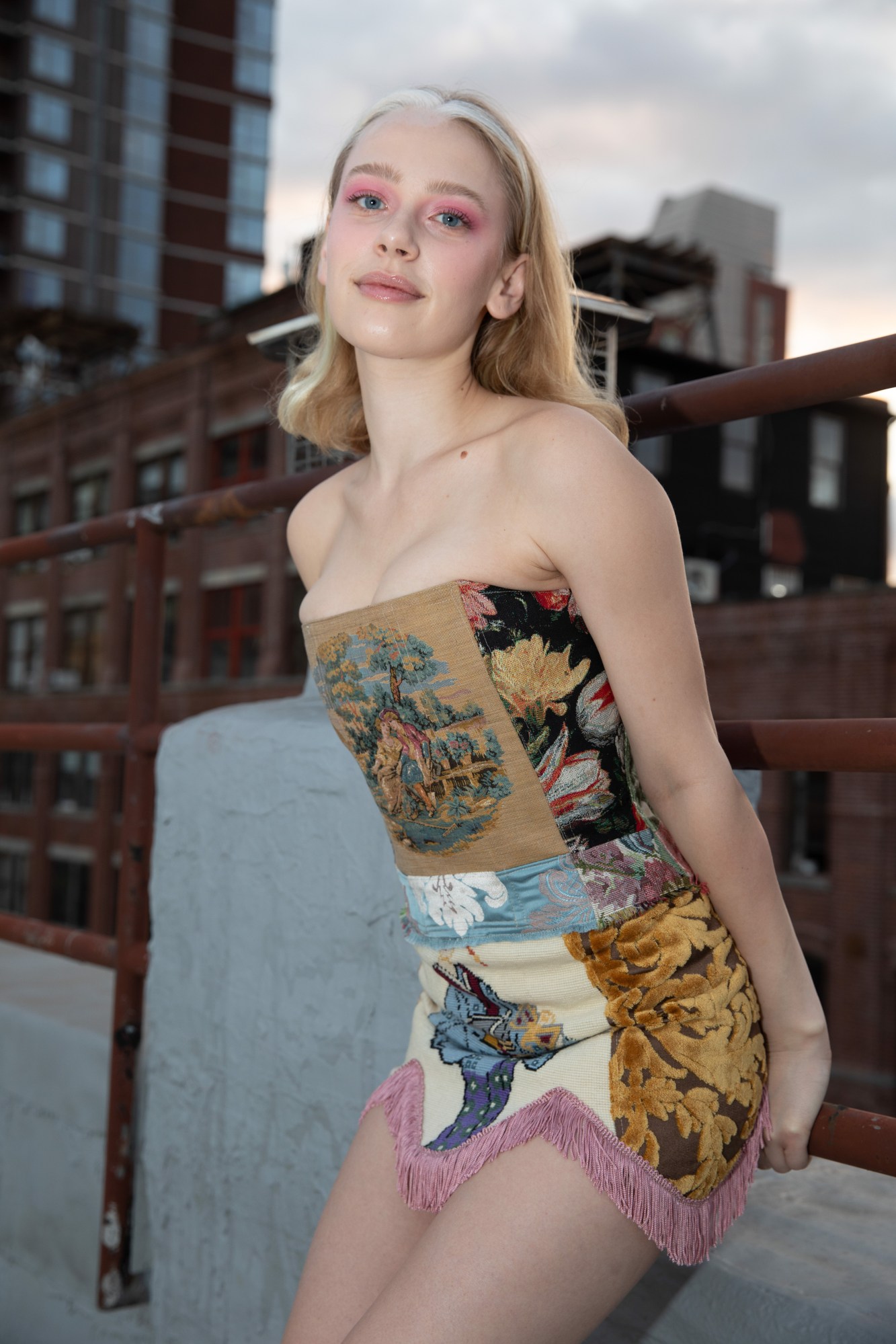 tia jonsson posing on a rooftop in a tapestry corset and skirt by kristin mallison