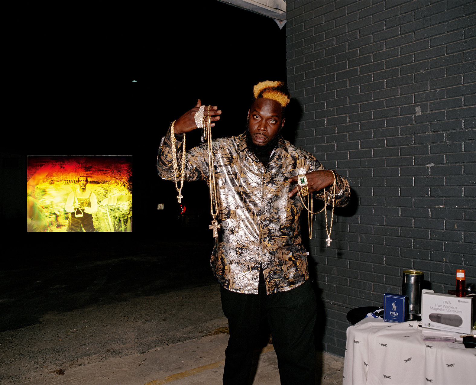 a man holding numerous gold crucifix chains