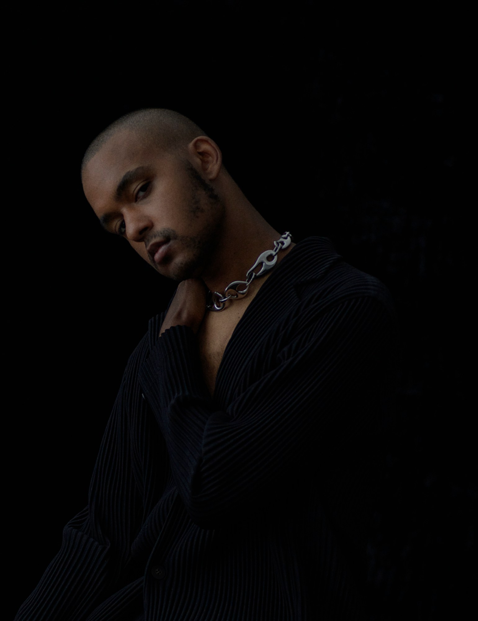 portrait of Jasper Marsalis wearing a black top and silver link chain.