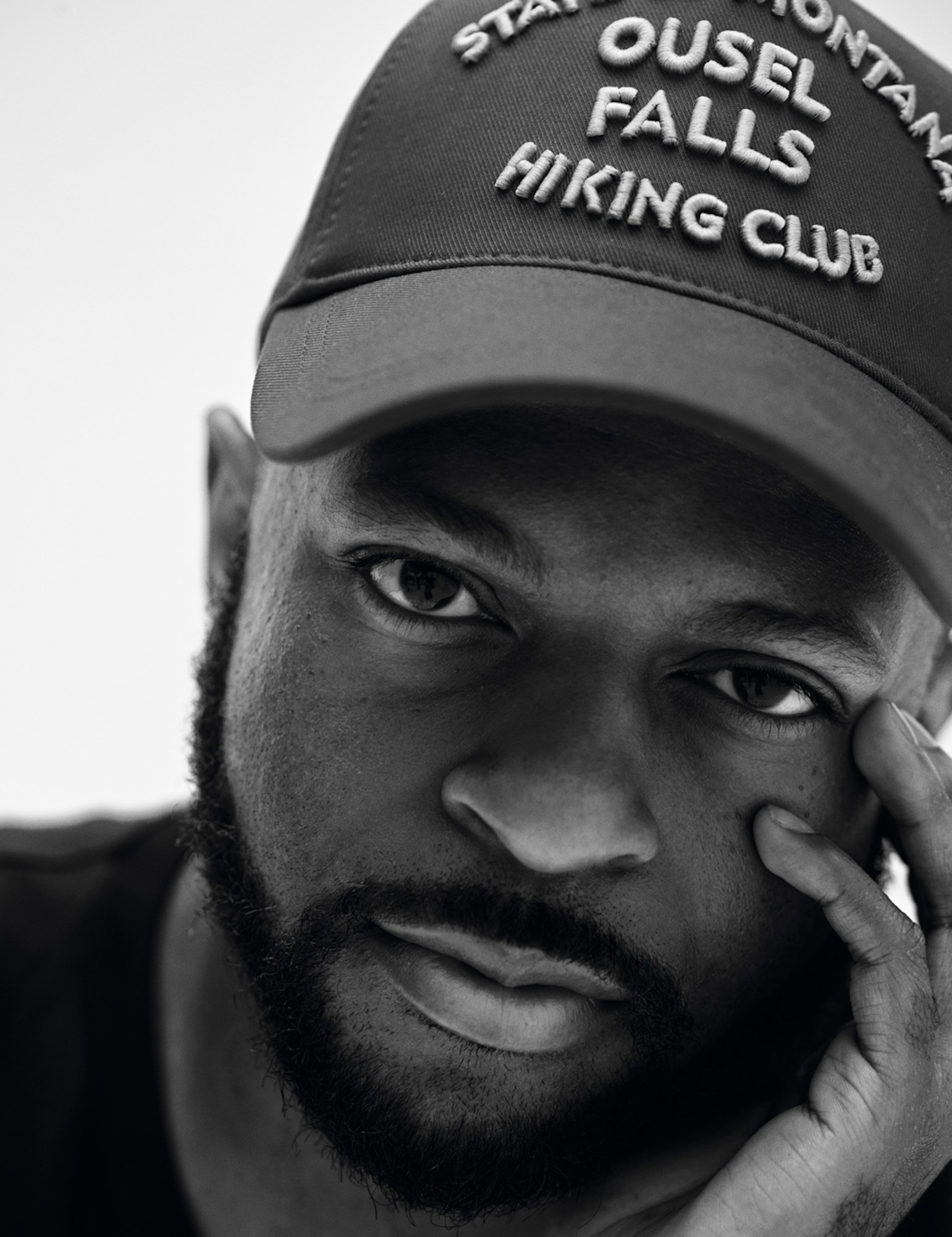 Close up portrait of Shikeith in black and white wearing a hat and black tee