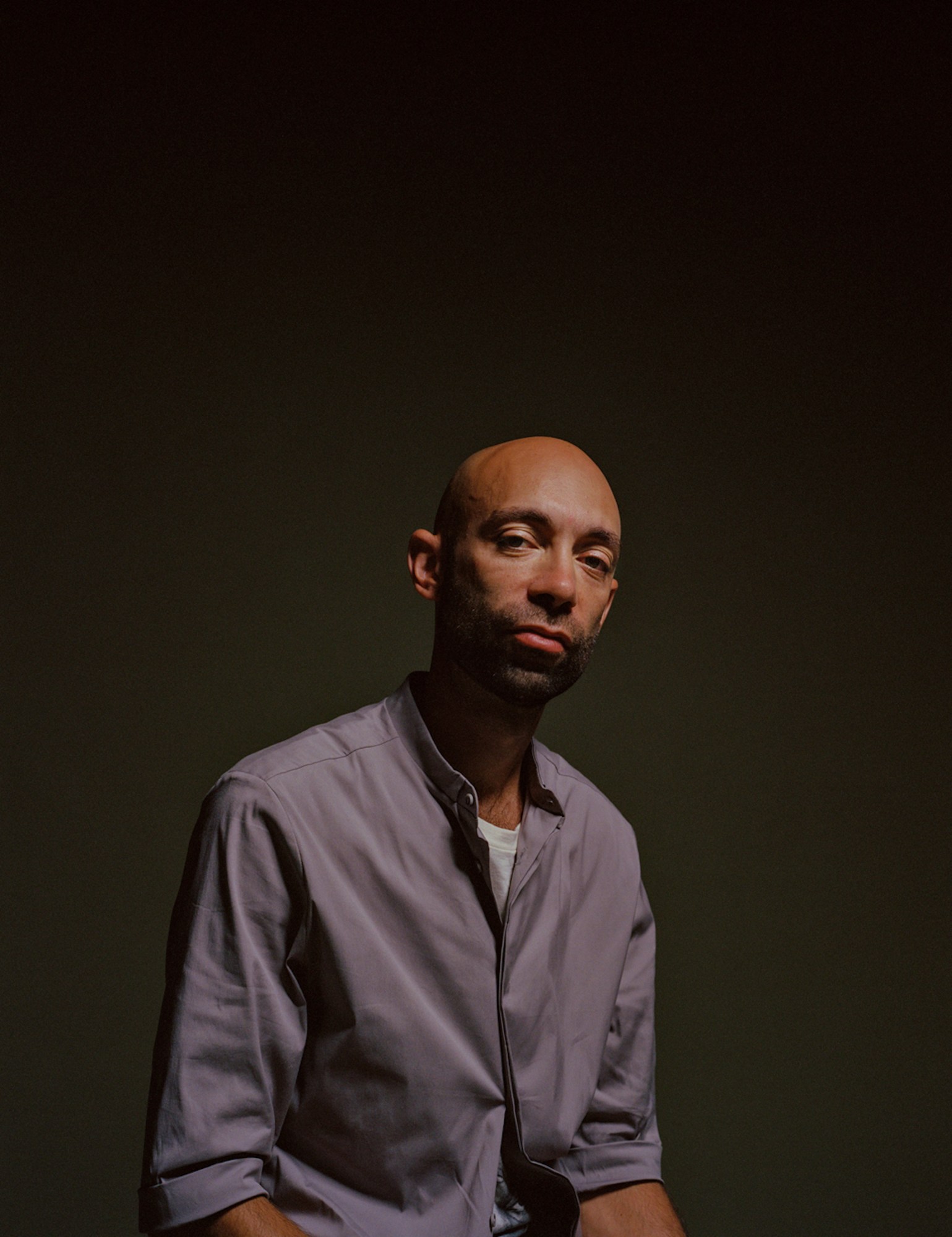 Portrait of Aaron Gilbert wearing a grey overshirt and a white t-shirt underneath