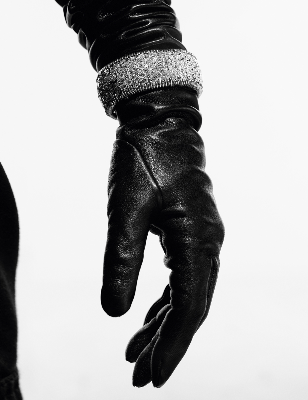 Close up of Kim's black leather glove with a diamond bracelet on it.