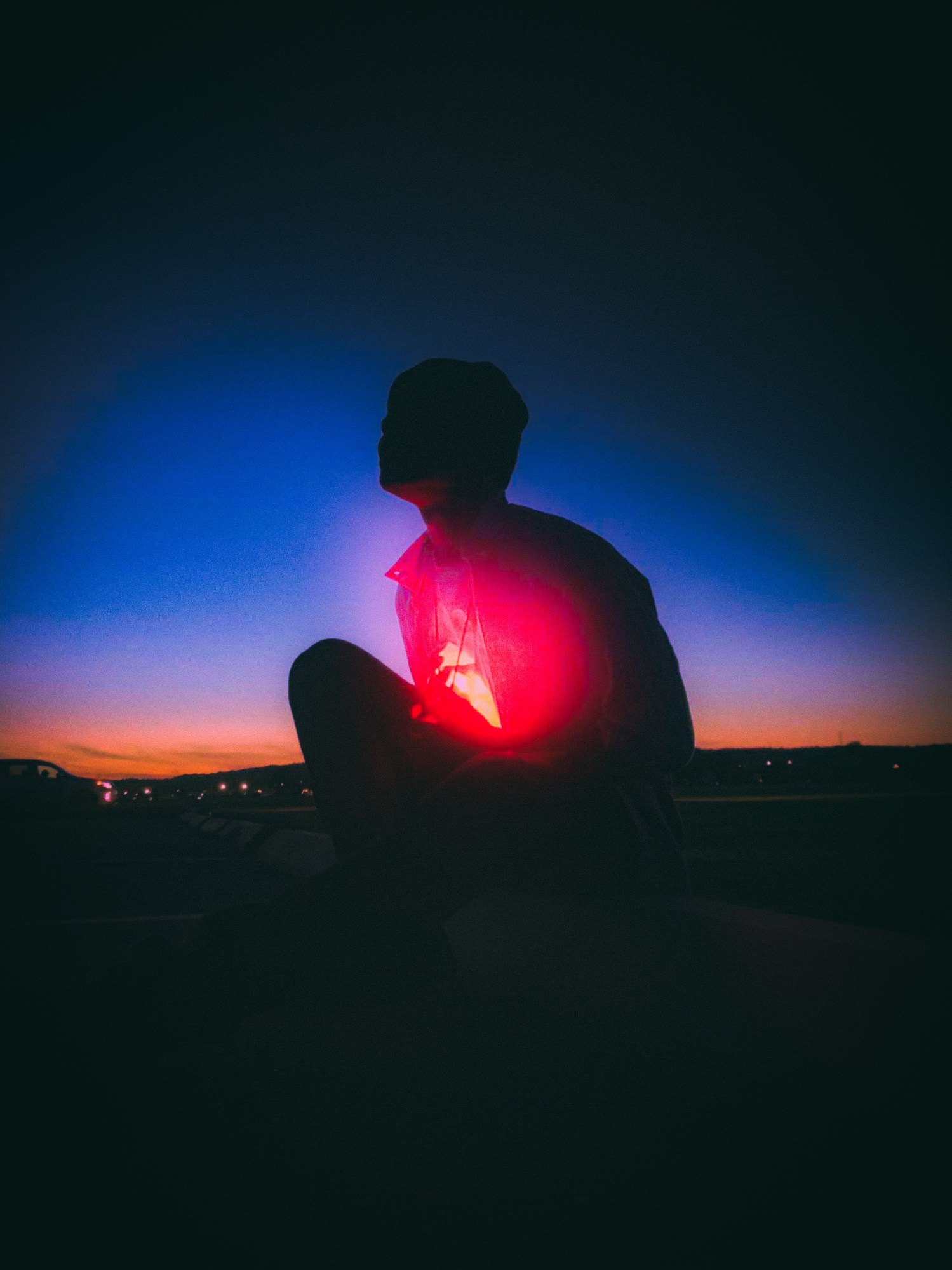 Boy clutching a red light at night.