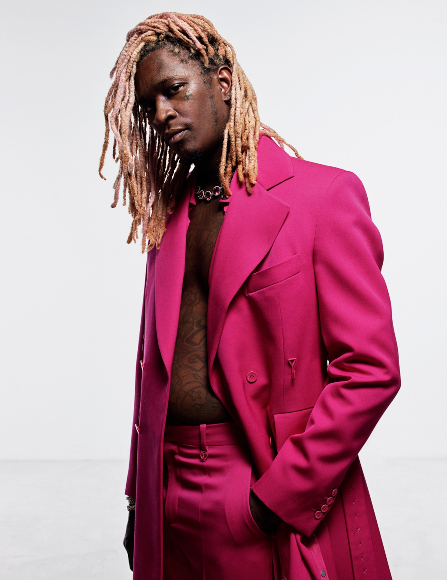 Young Thug wearing a hot pink suit and no shirt with Tiffany jewellery.