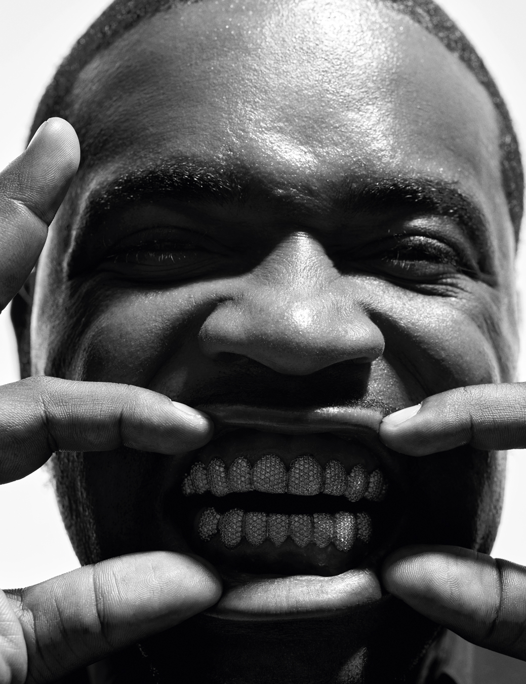 close up of A$AP Ferg face as he pulls back his lips to reveal a diamond encrusted grill.