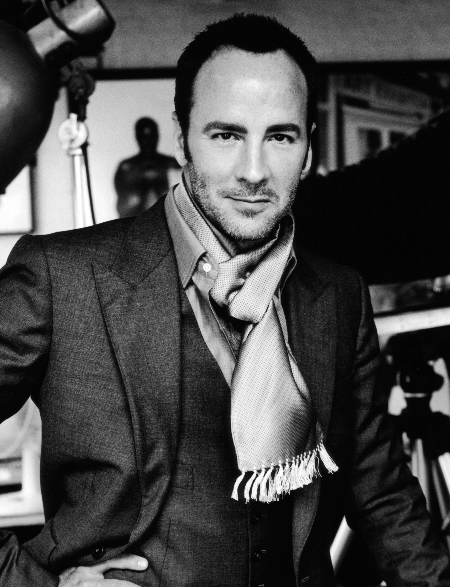 Tom Ford wearing a suit and scarf on a set.