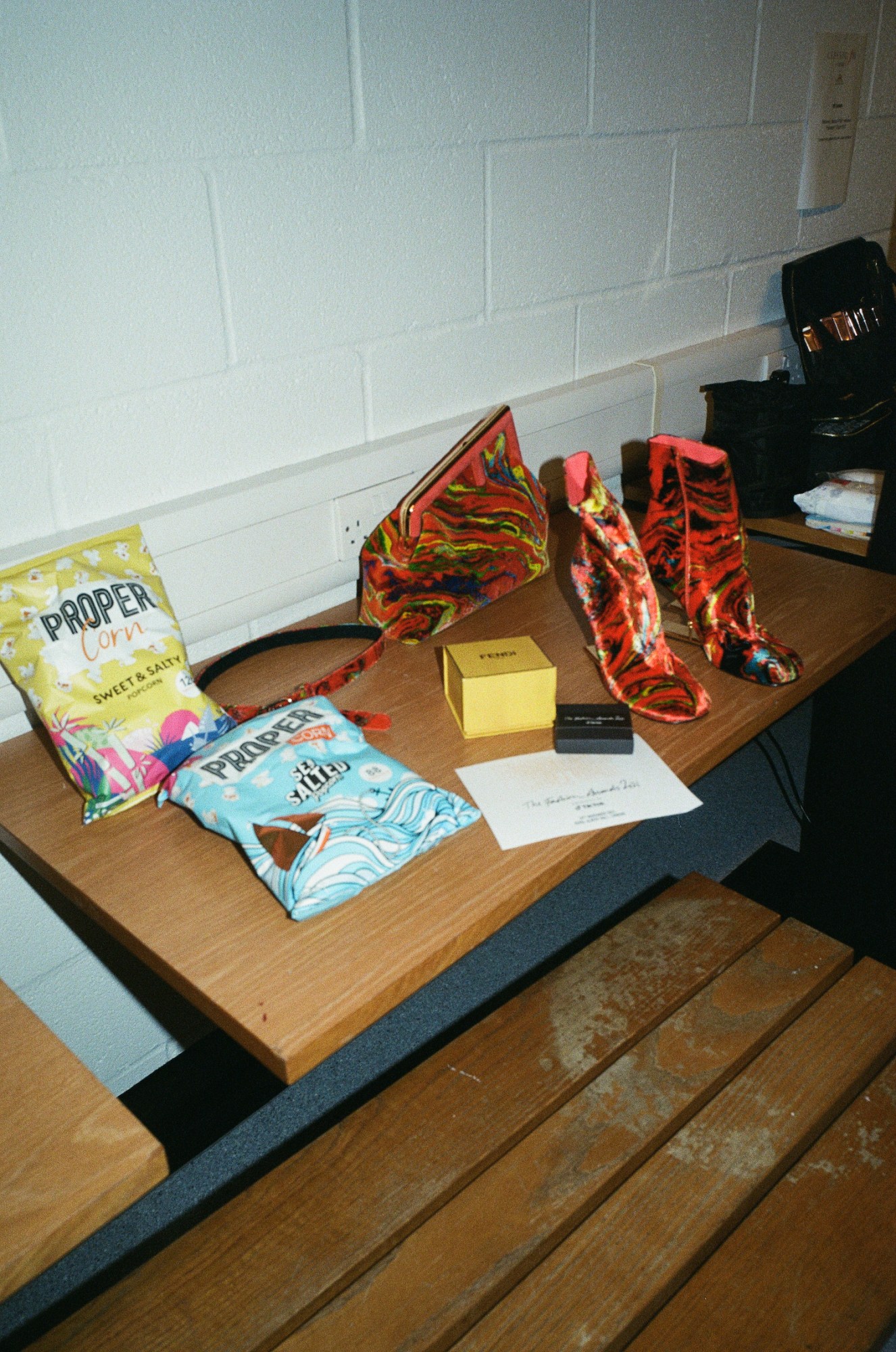 Popcorn and a pair of shoes on a wooden bench