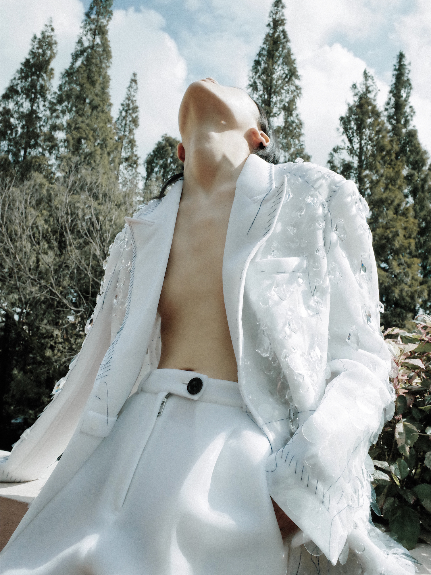 A model wearing a crystal embroidered Peter Do coat and looking up at the sky