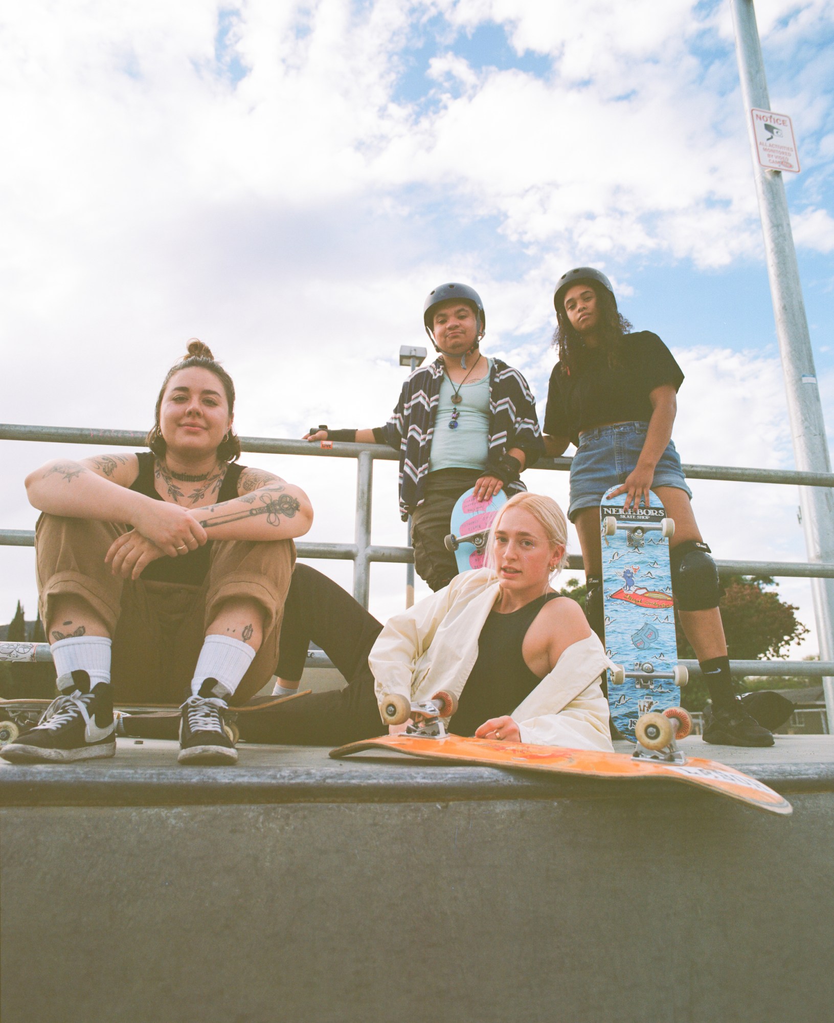 members of queer skate collective boos cruise sitting with their boards on a ramp