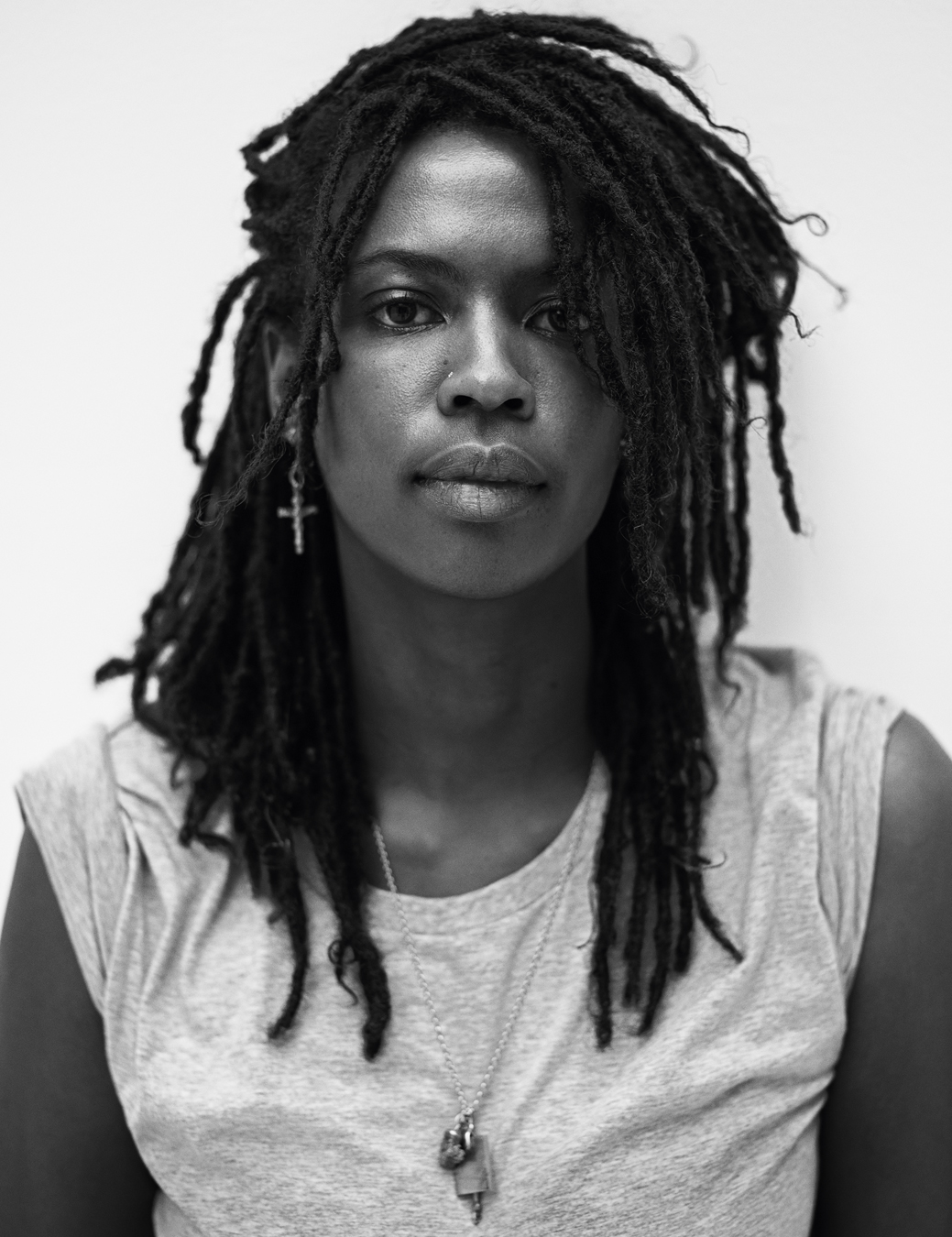 Portrait of Kandis wearing a grey vest top and a necklace.