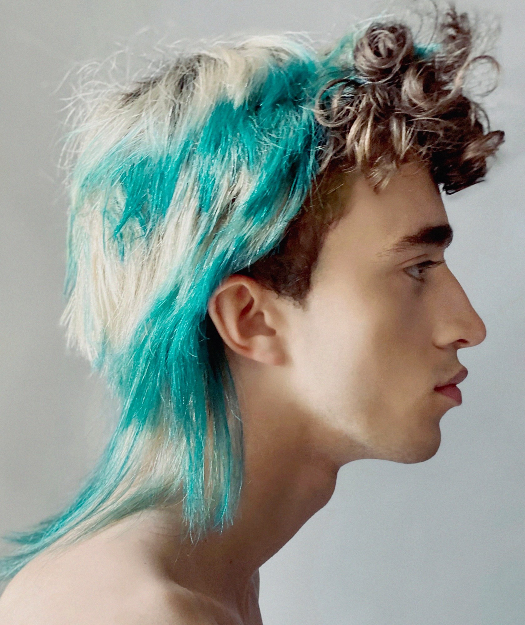 A model wearing a turquoise and white mullet wig