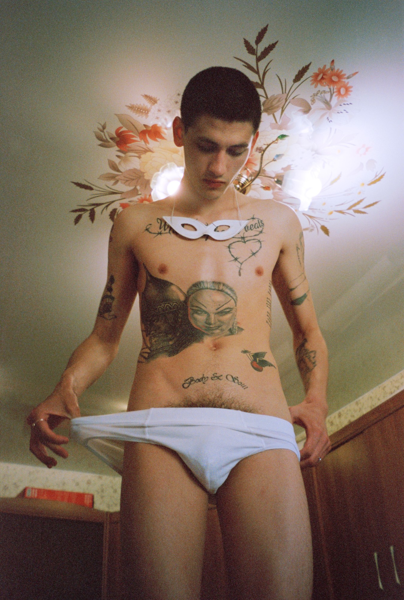 vlad zorin portrait of a man with tattoos pulling down his pants to reveal pubic hair