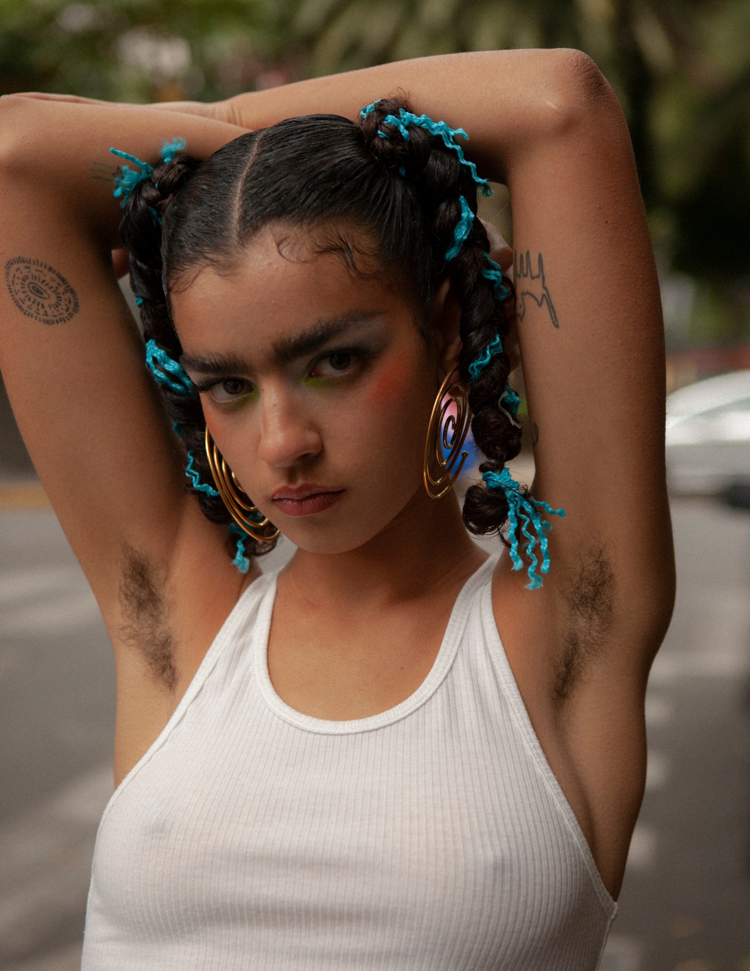 model maria gonzalez rojas posing in a white tank top with her arms up