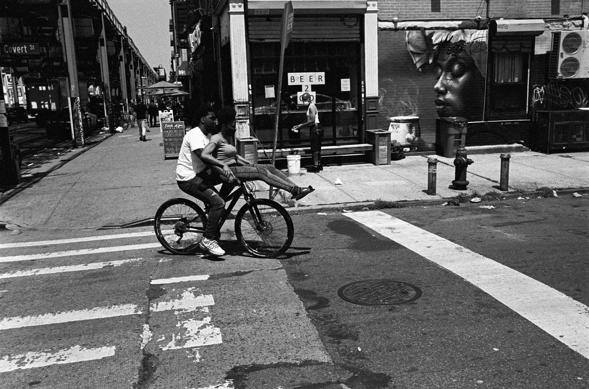 two people riding a bicycle in new york city by christopher currence