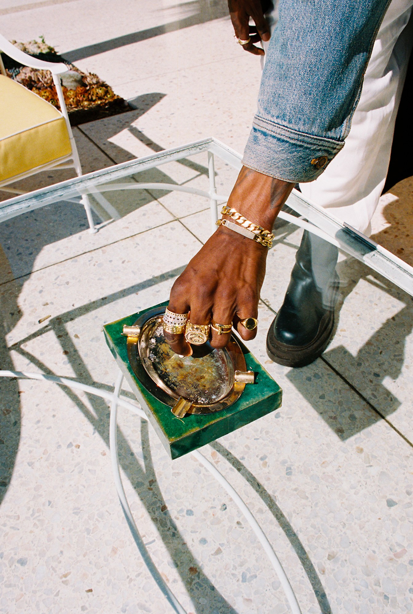 A$AP Nast's arm reaching down to put out a cigarette on a jade stone gold plated ash tray photographed by Bladimir Corniel