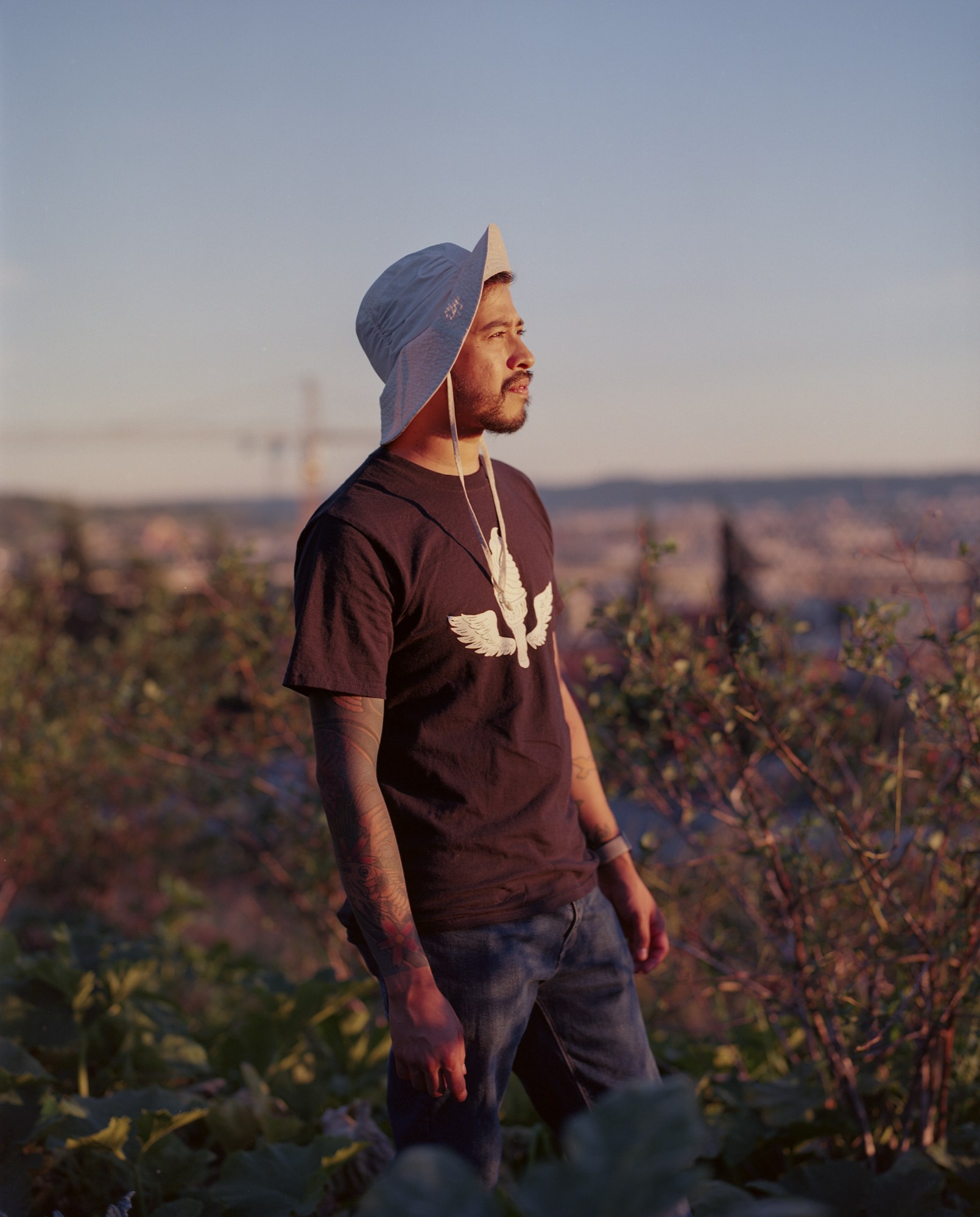 a volunteer in a bucket hat standing in the middle of flowers at yes farm