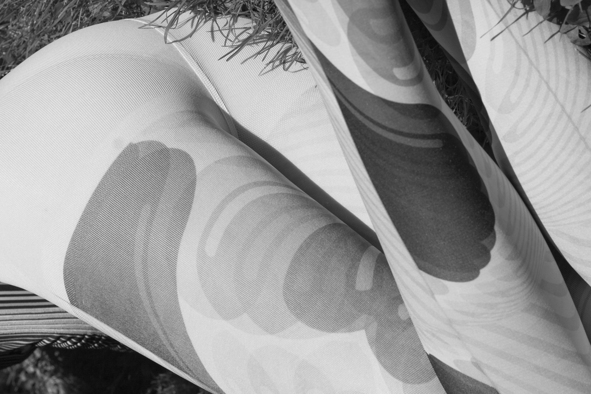 a woman lies in grass wearing patterned tights