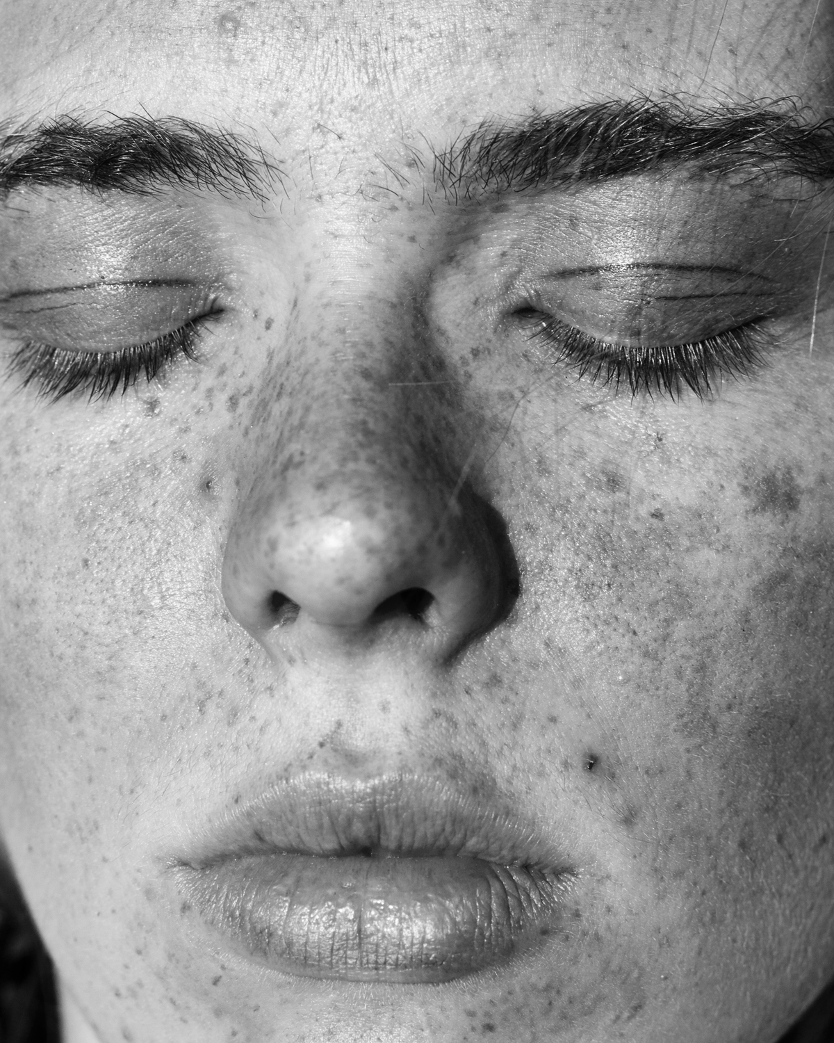 a close up black and white portrait of a woman with freckles