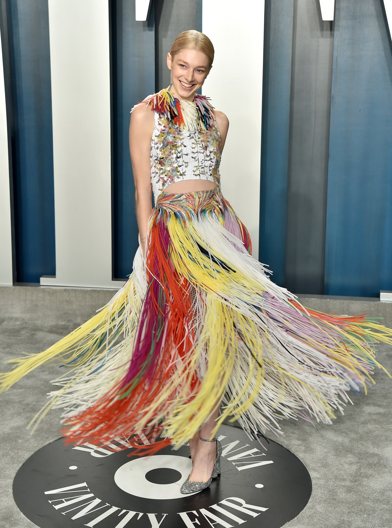 hunter schafer posing at the vanity fair oscars party in a rainbow fringed givenchy gown 2021