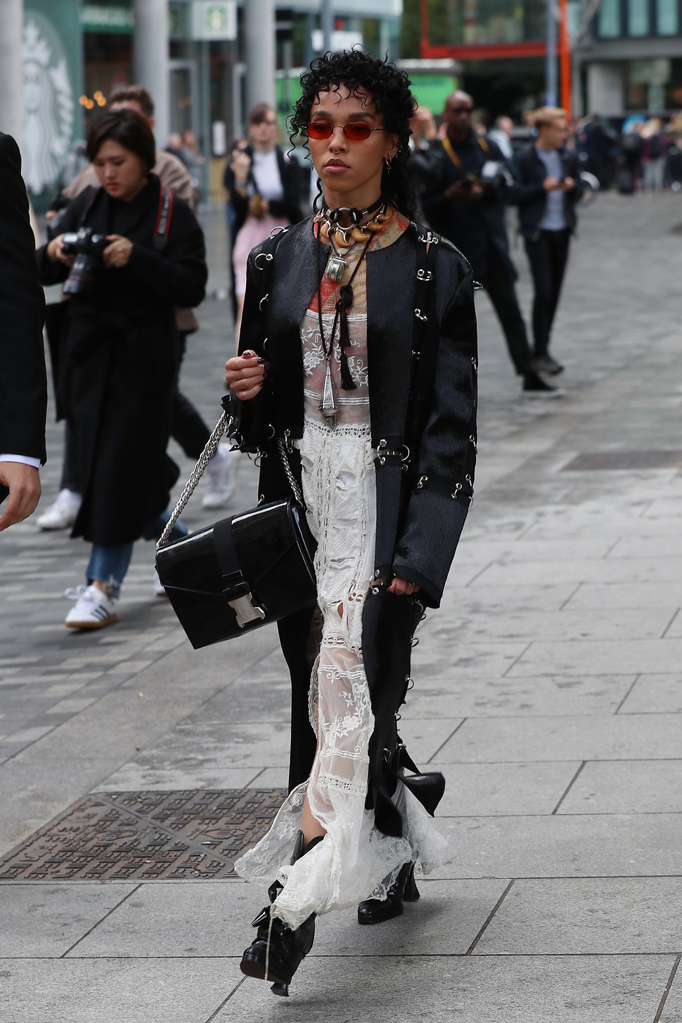 fka twigs walking down the street in london wearing a black jacket and tinted sunglasses 2017