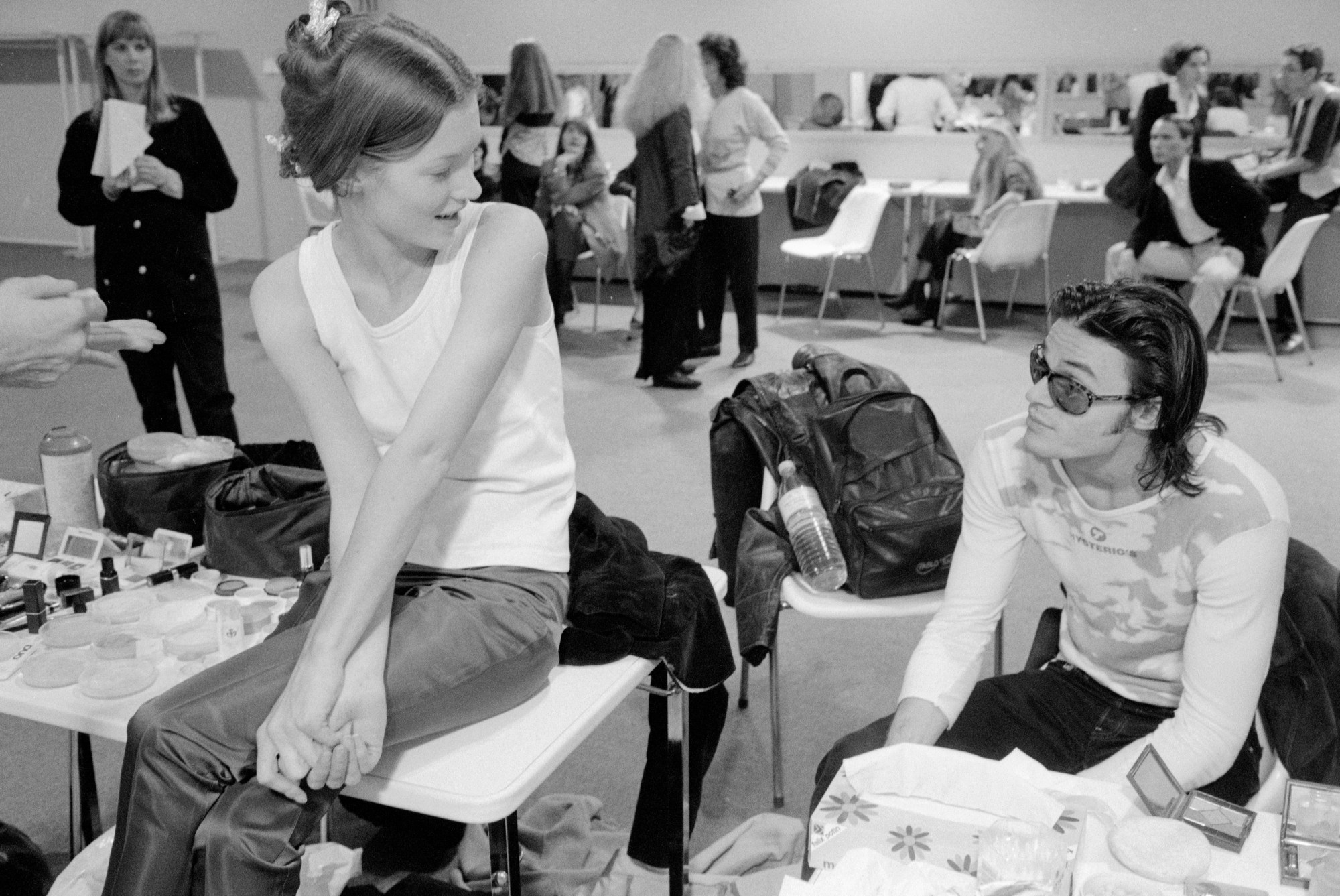 kate moss sitting on a table backstage at paris fashion week with mario sorrenti 1991