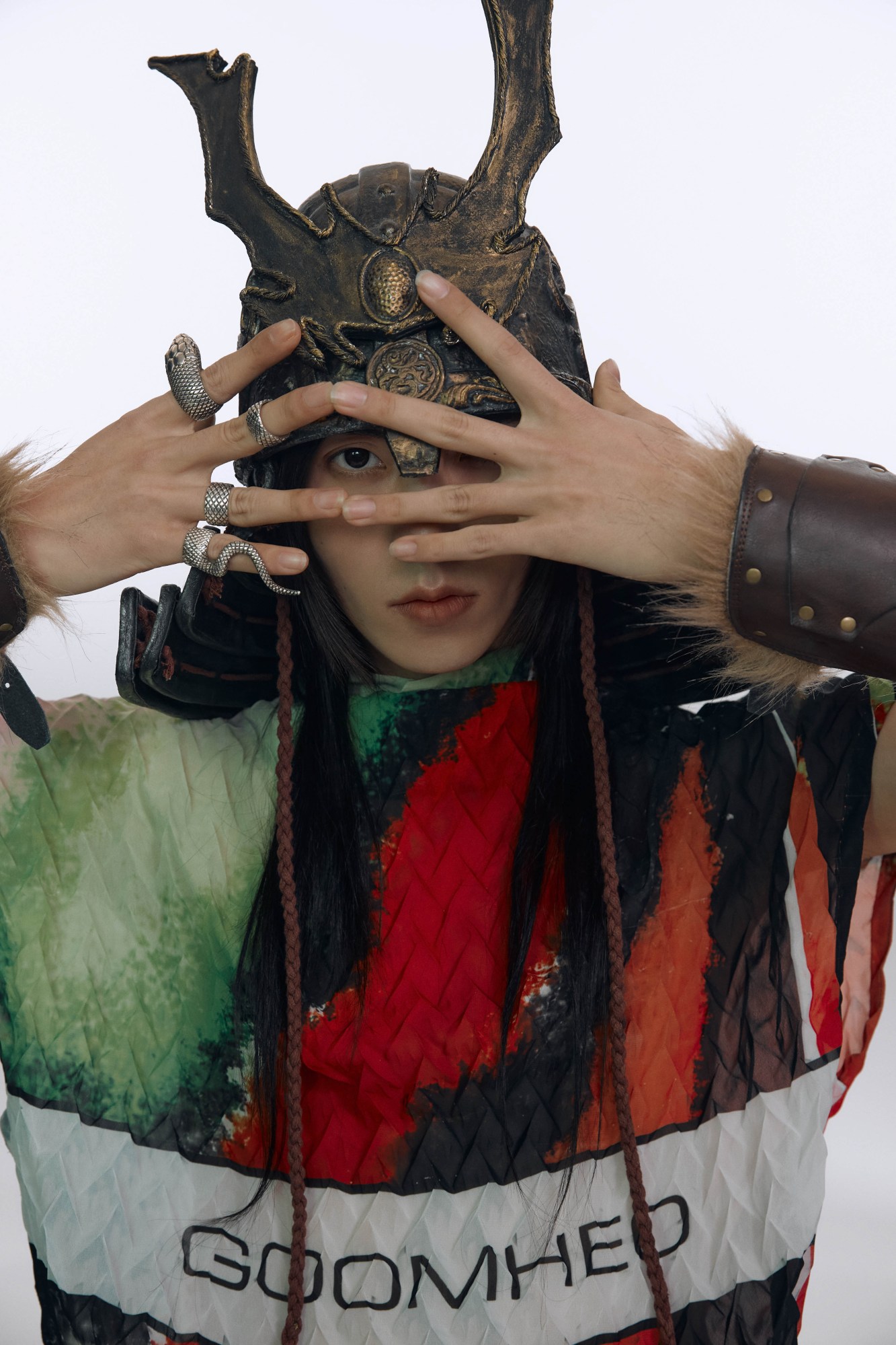 a model wears a pleated colourful GOOMHEO top with a traditional korean helmet