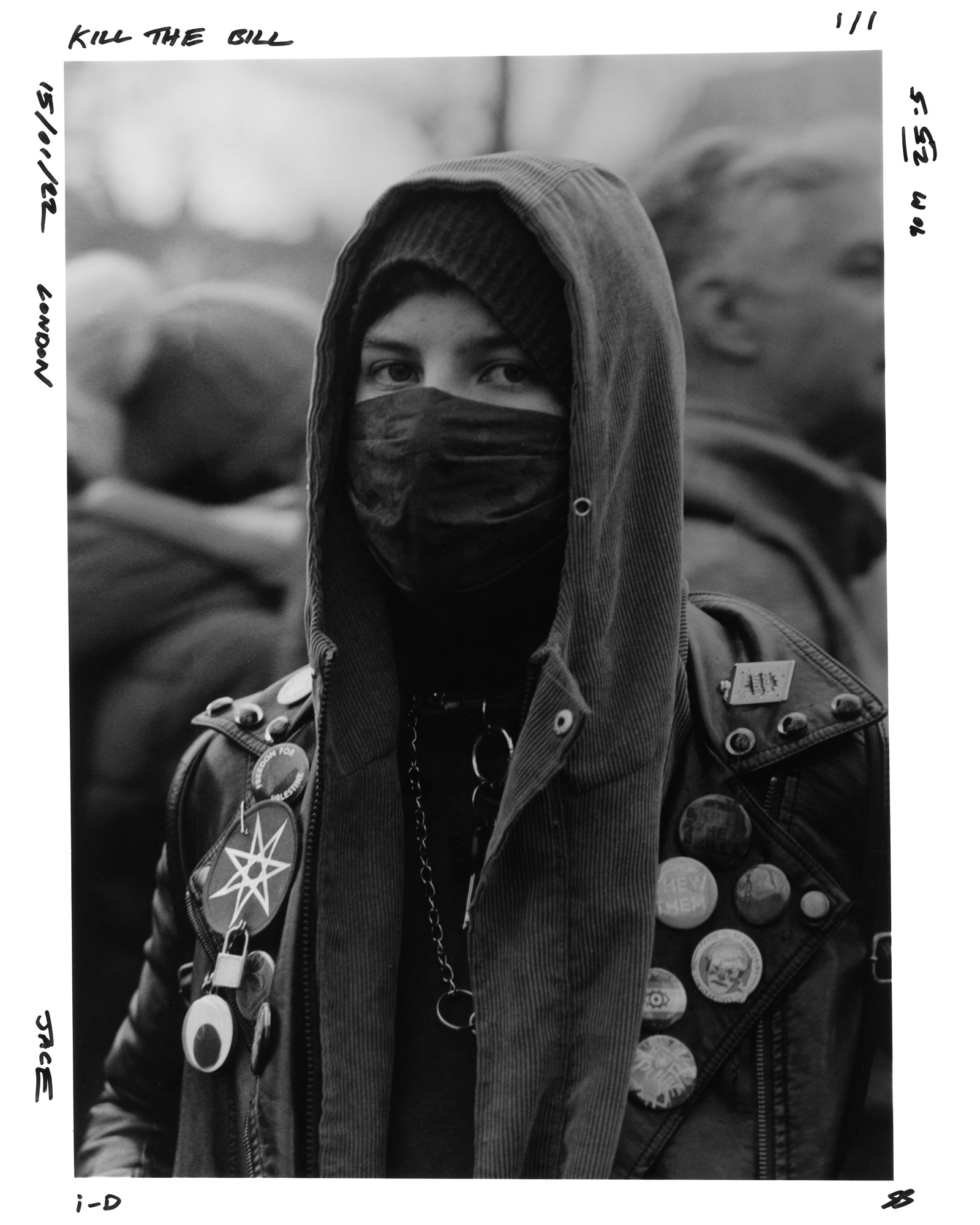 Protester in a hoodie, face mask and leather jacket covered in badges at the Kill the Bill protest