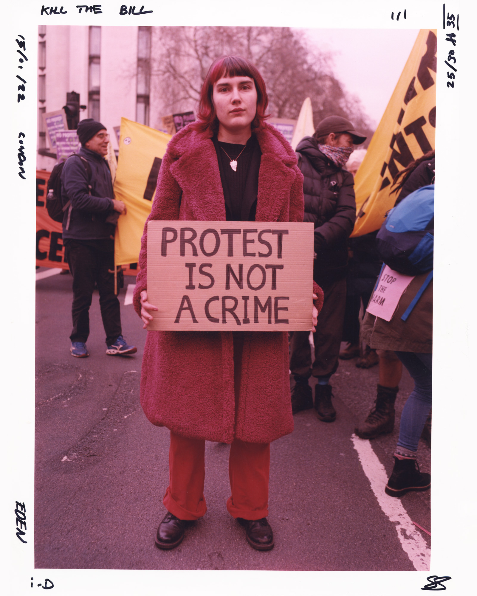 Protester in all red holding a sign saying protest is not a crime at the Kill the Bill protest