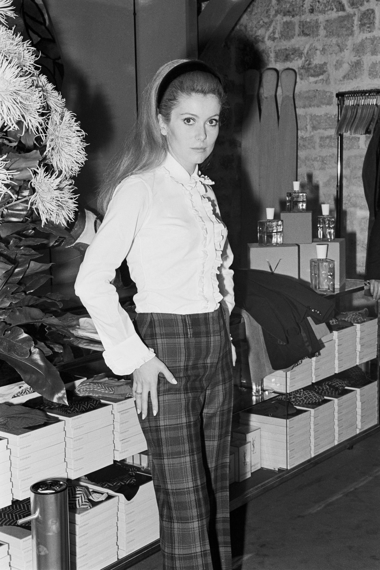 catherine deneuve wearing a saint laurent top and plaid trousers