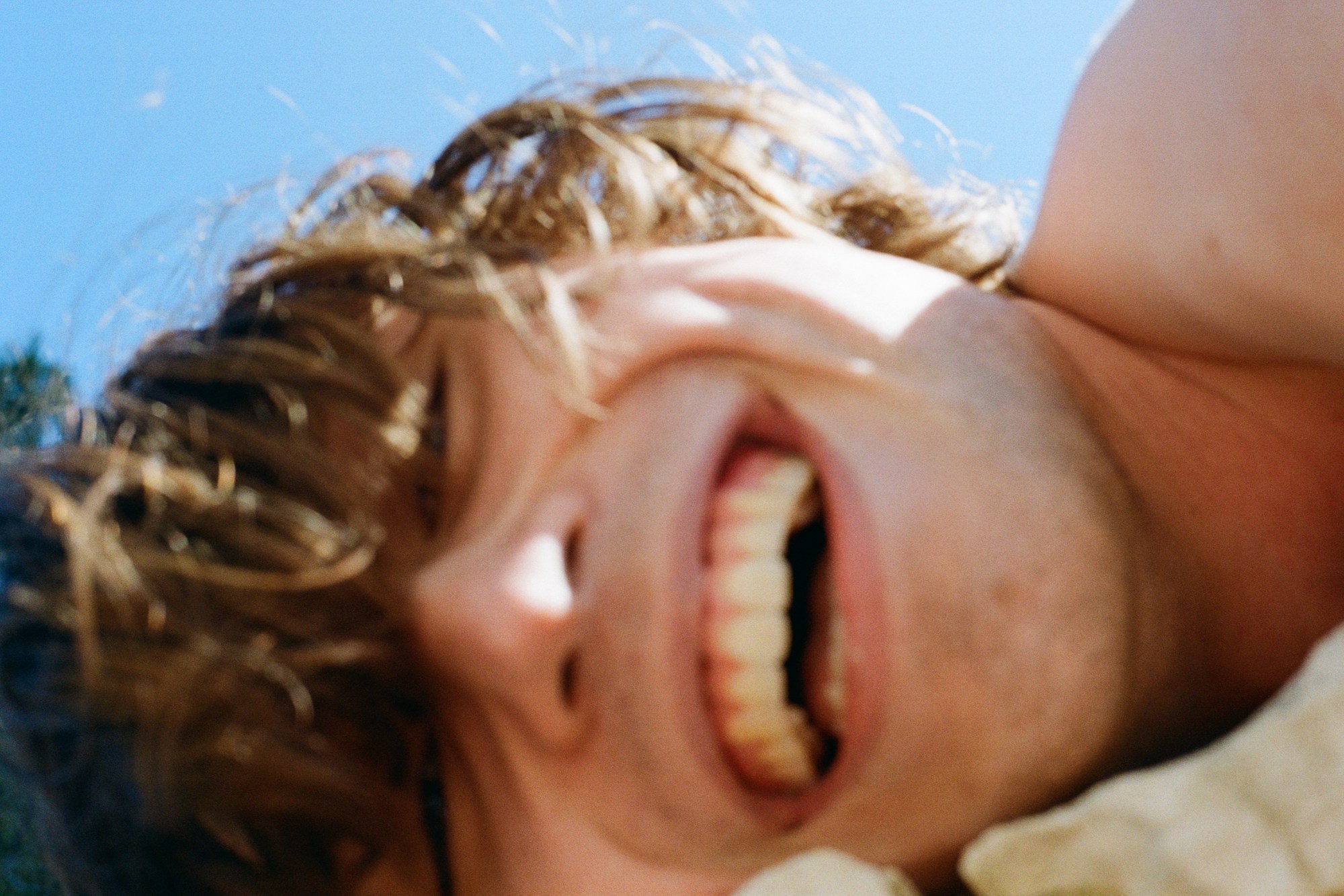 close up of a man lying down and smiling.