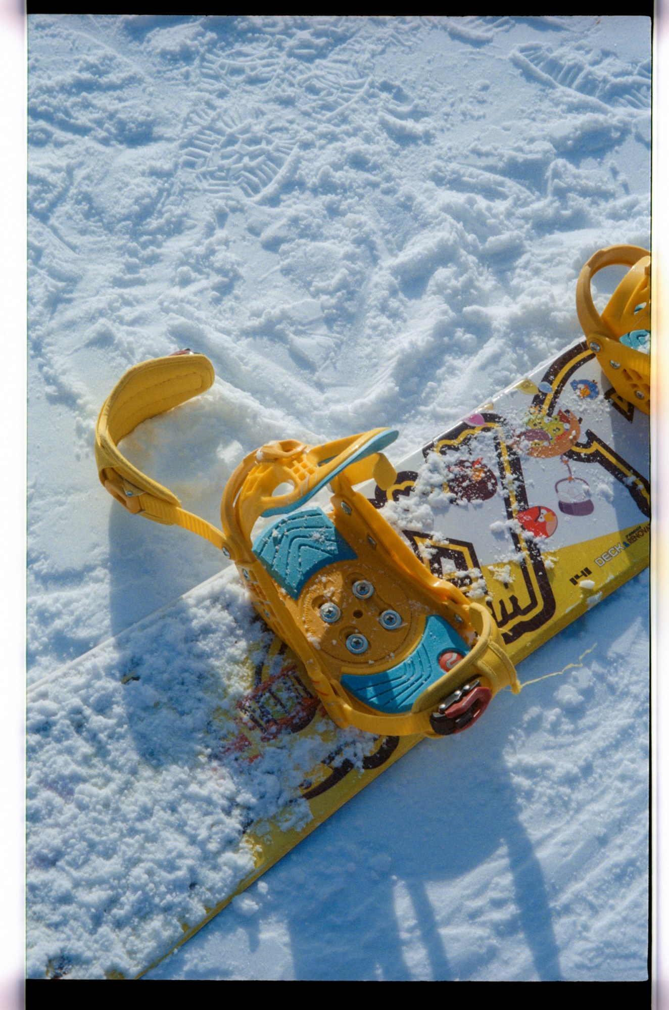 Snow covered yellow snowboard