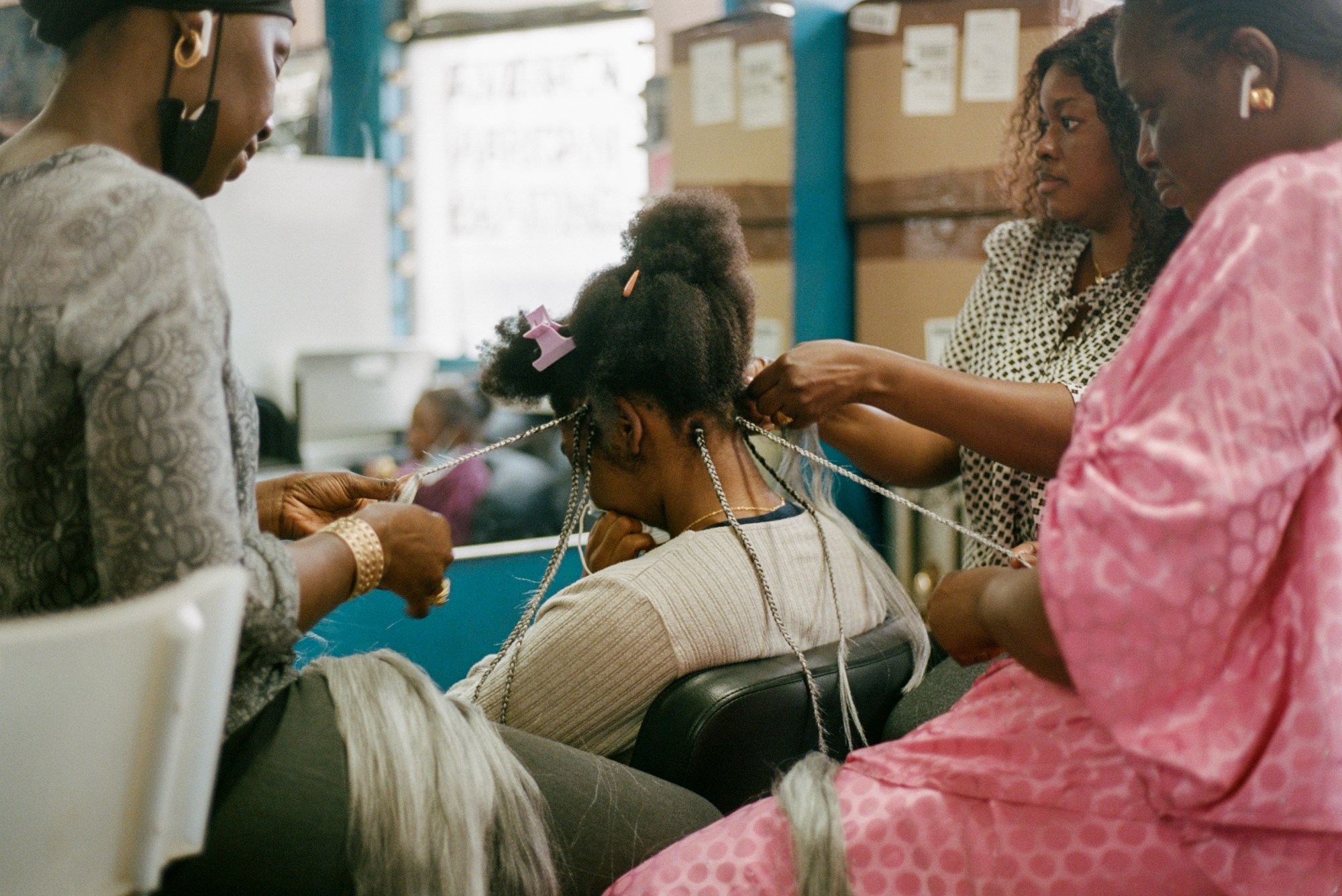 a woman having her hair braided in a salon