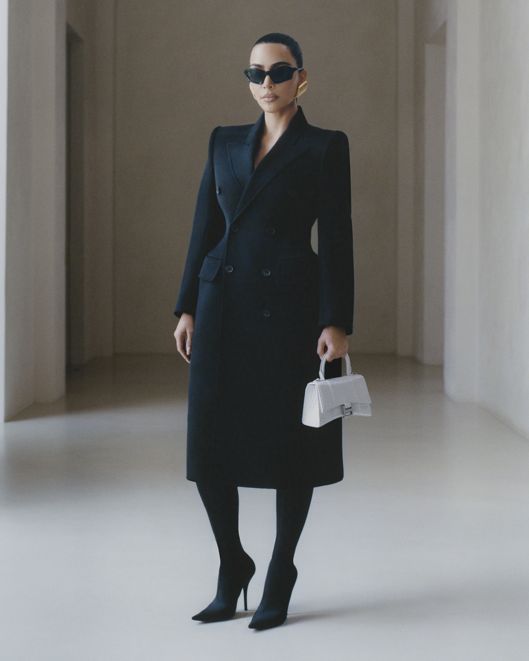 Kim Kardashian in Balenciaga's black hourglass coat in her home