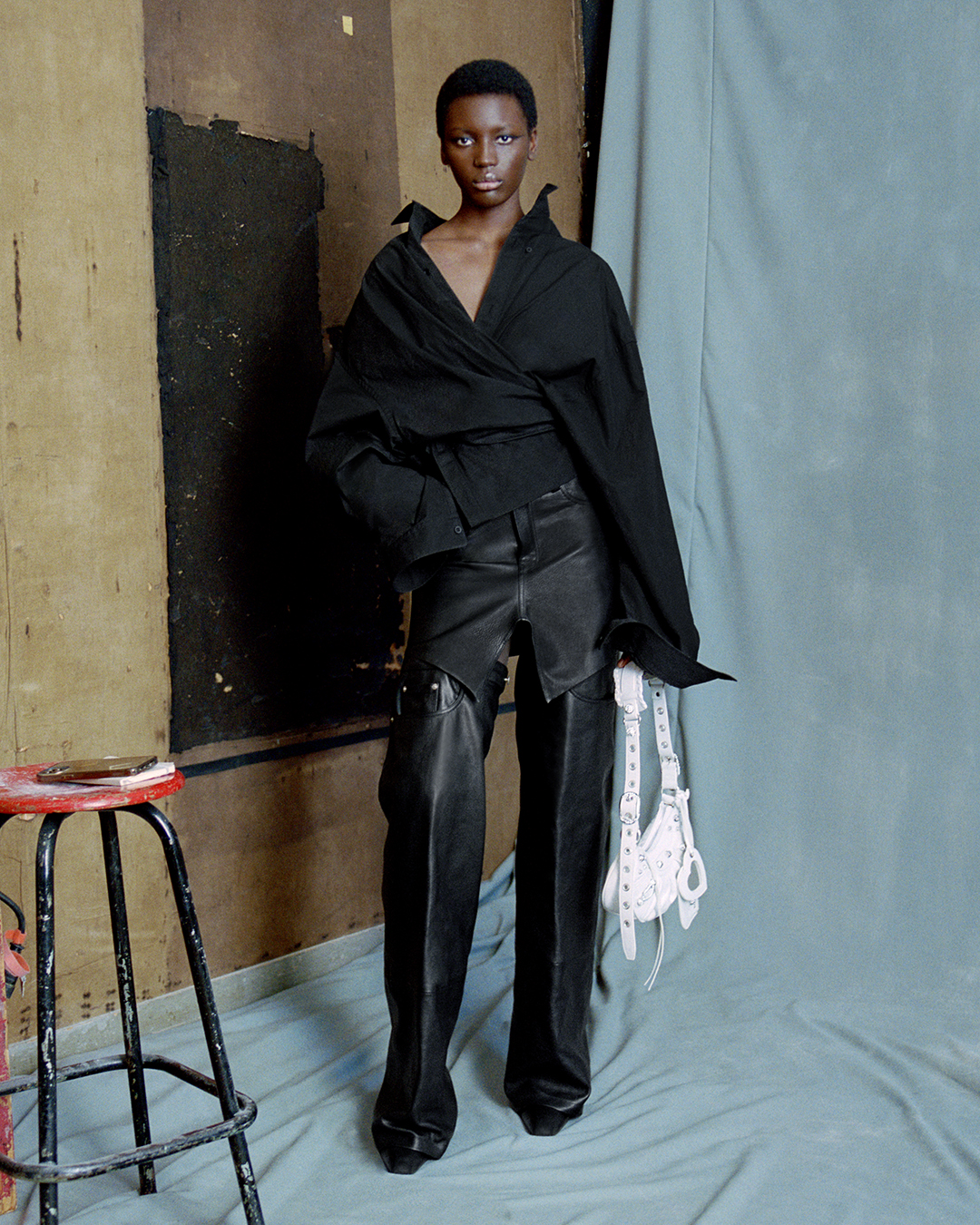 Marie Agnes Diene posing with Balenciaga's Le Cagole bag in white in her home