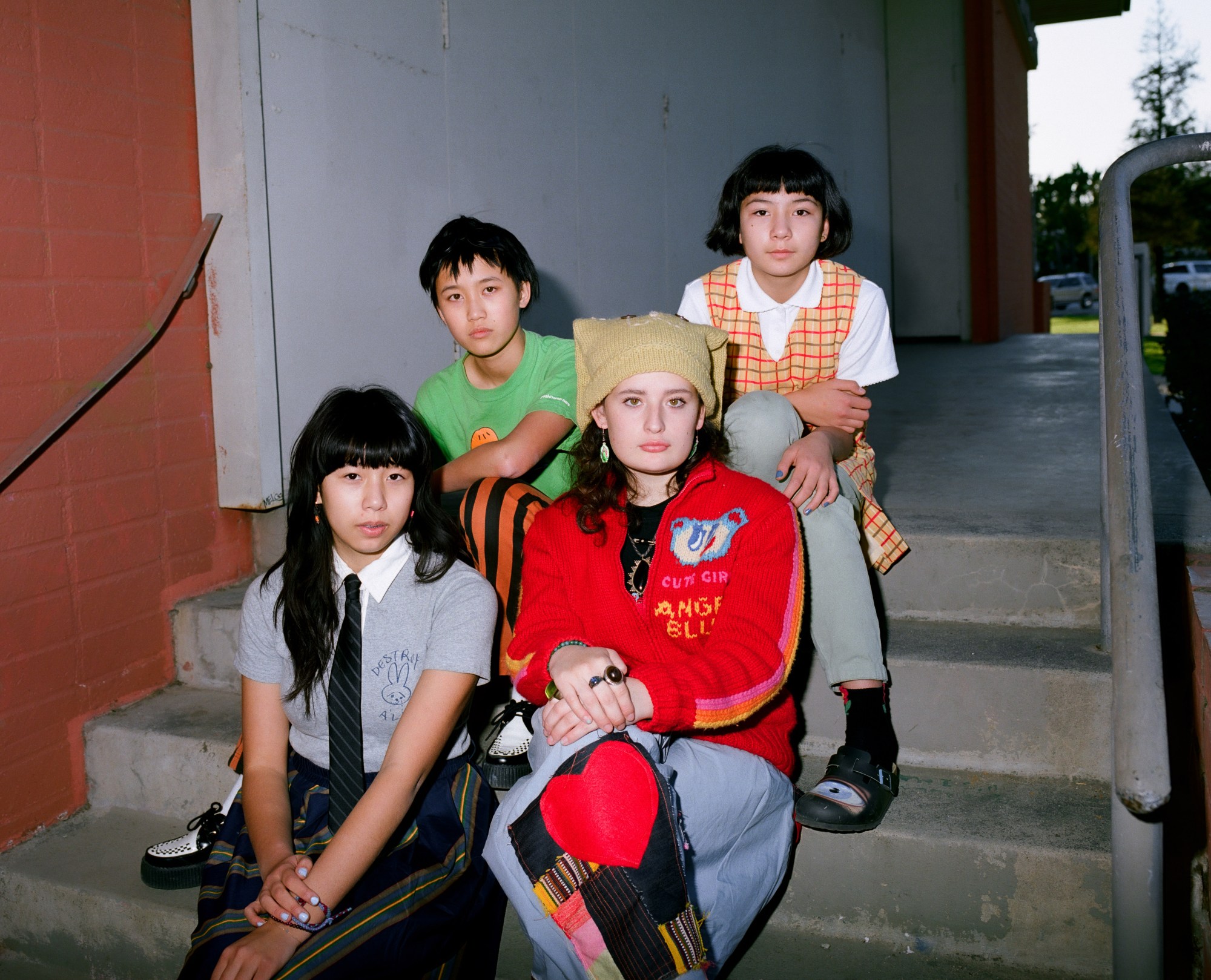 The Linda Lindas hang out in an outside stairwell in LA