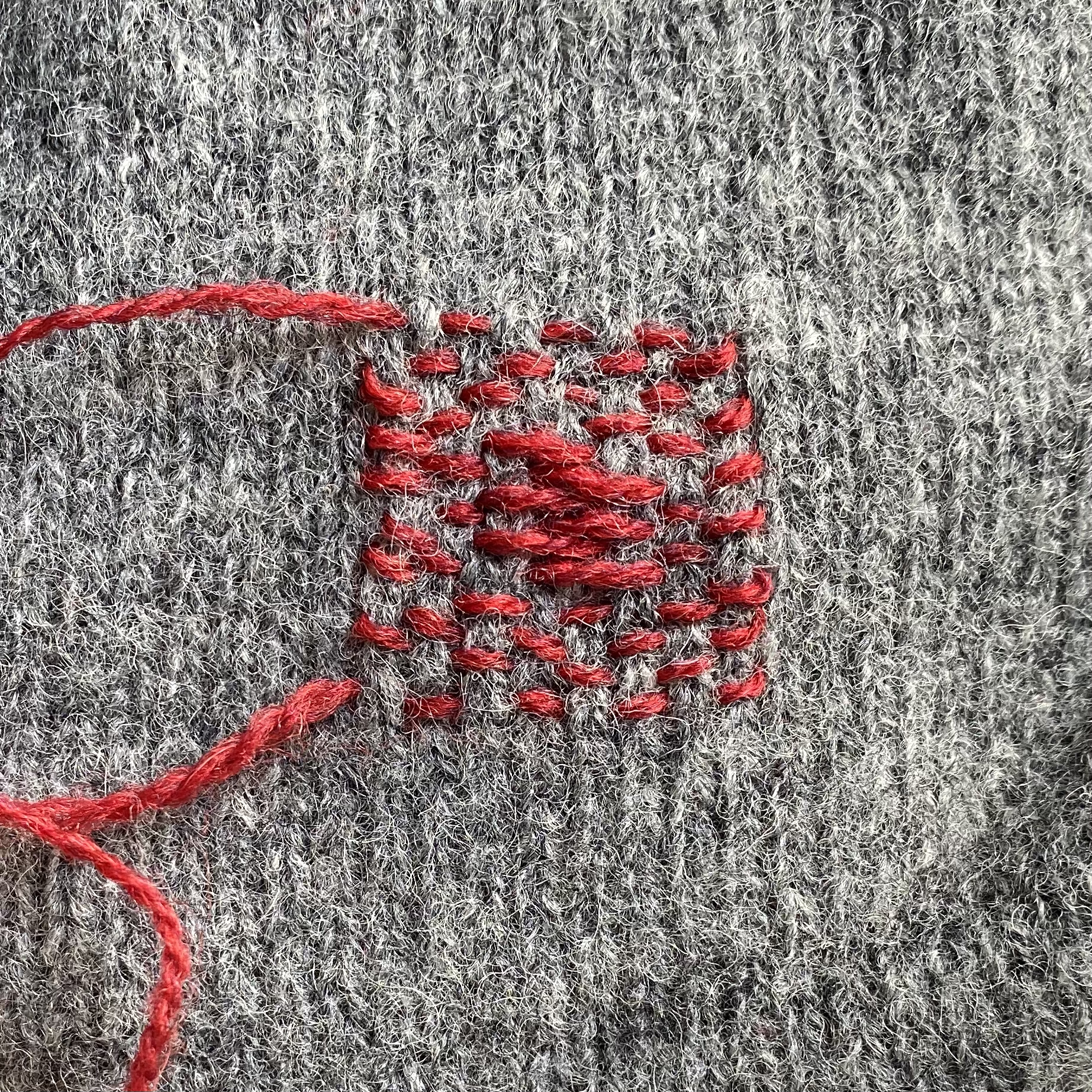 Close up image of darning showing the warp stitch