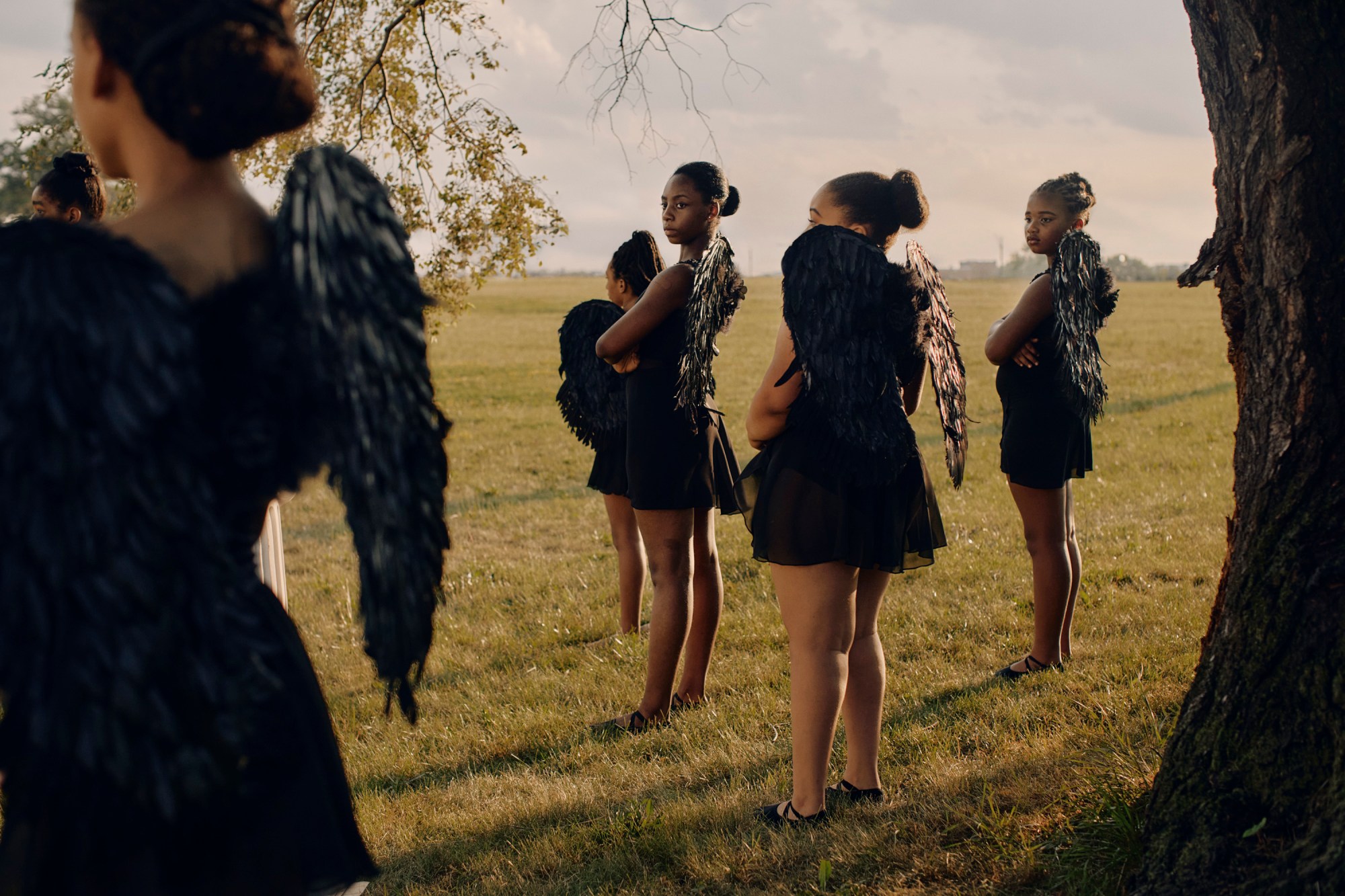 a group of young women wearing wings stood in a field