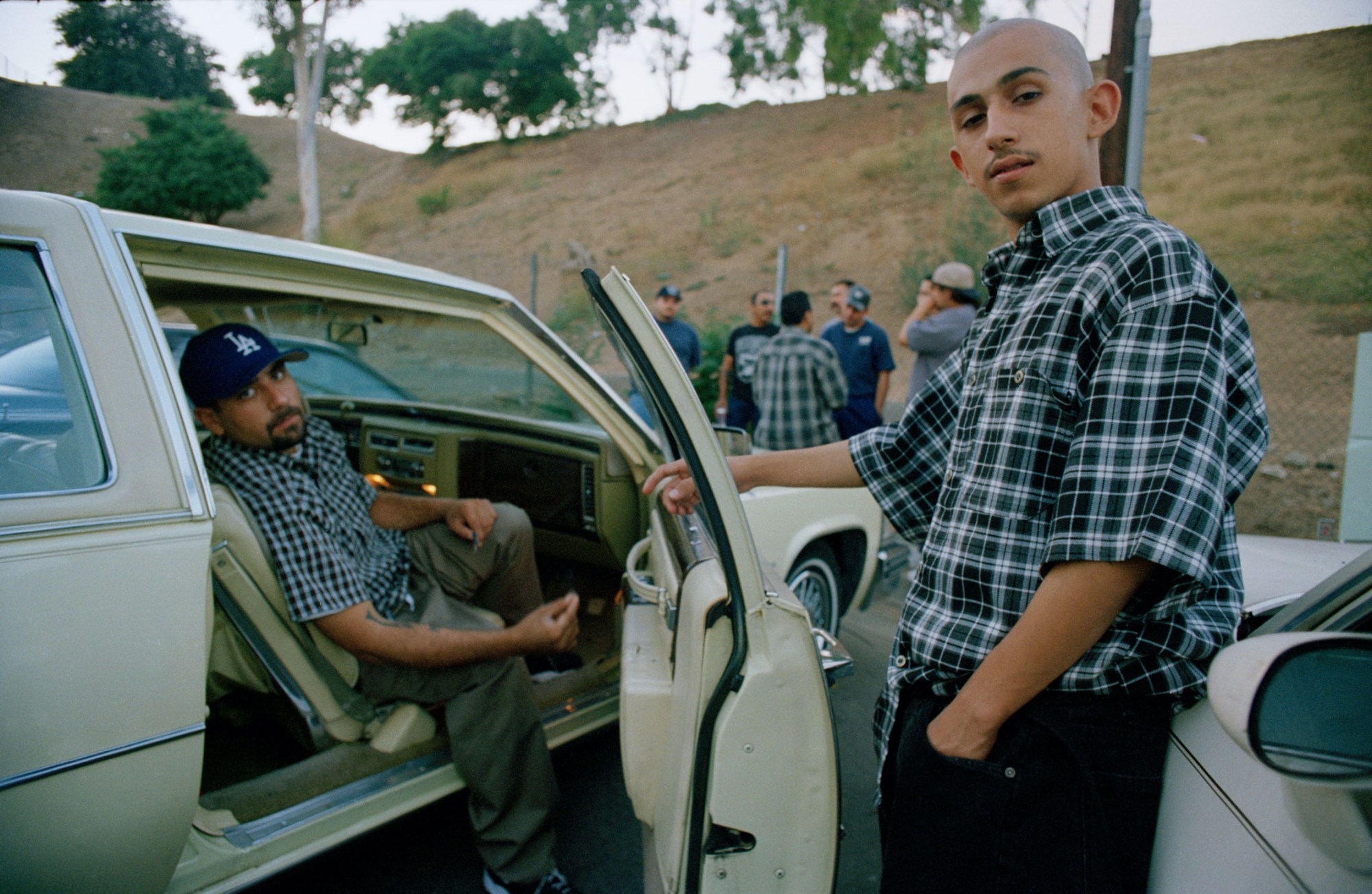 men hang out in a parking lot in east la